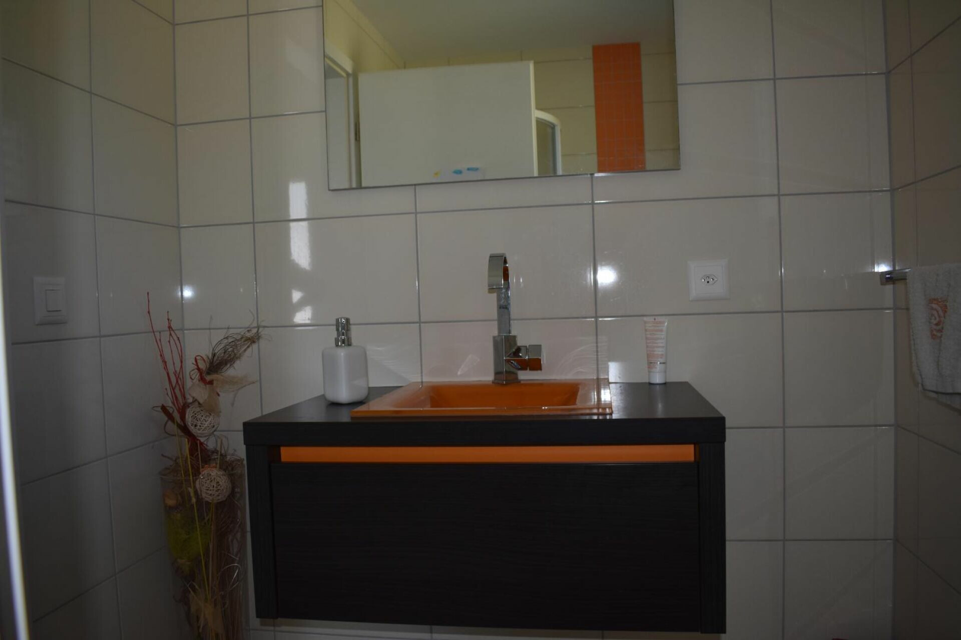 Modernes Badezimmer mit orangefarbenem Waschtisch