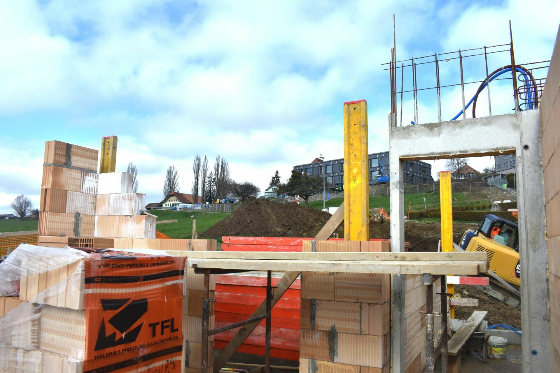 Baustelle eines Rohbaus mit Mauerwerk und Betonstützen