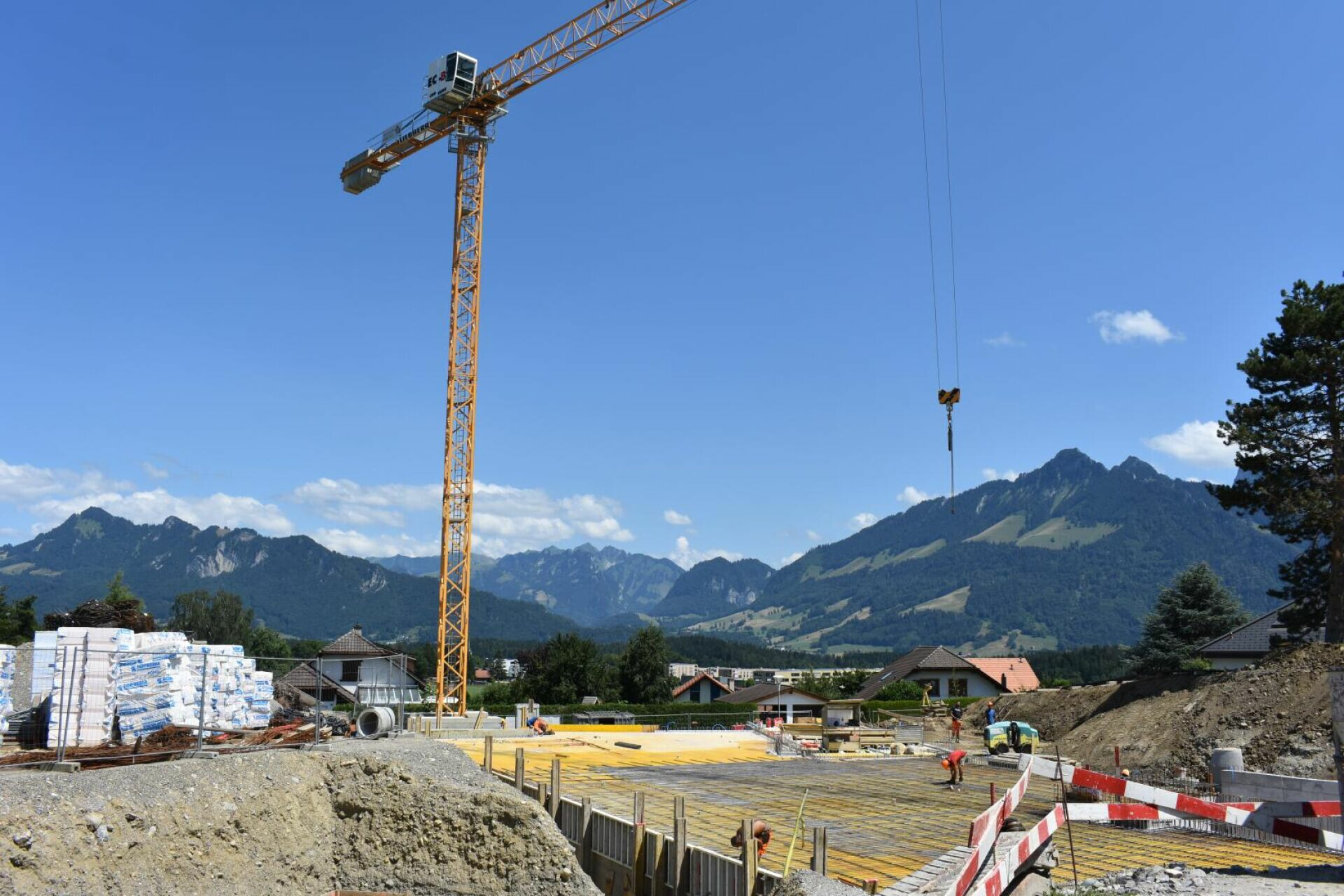 Baugrundstück mit Kran vor Bergpanorama
