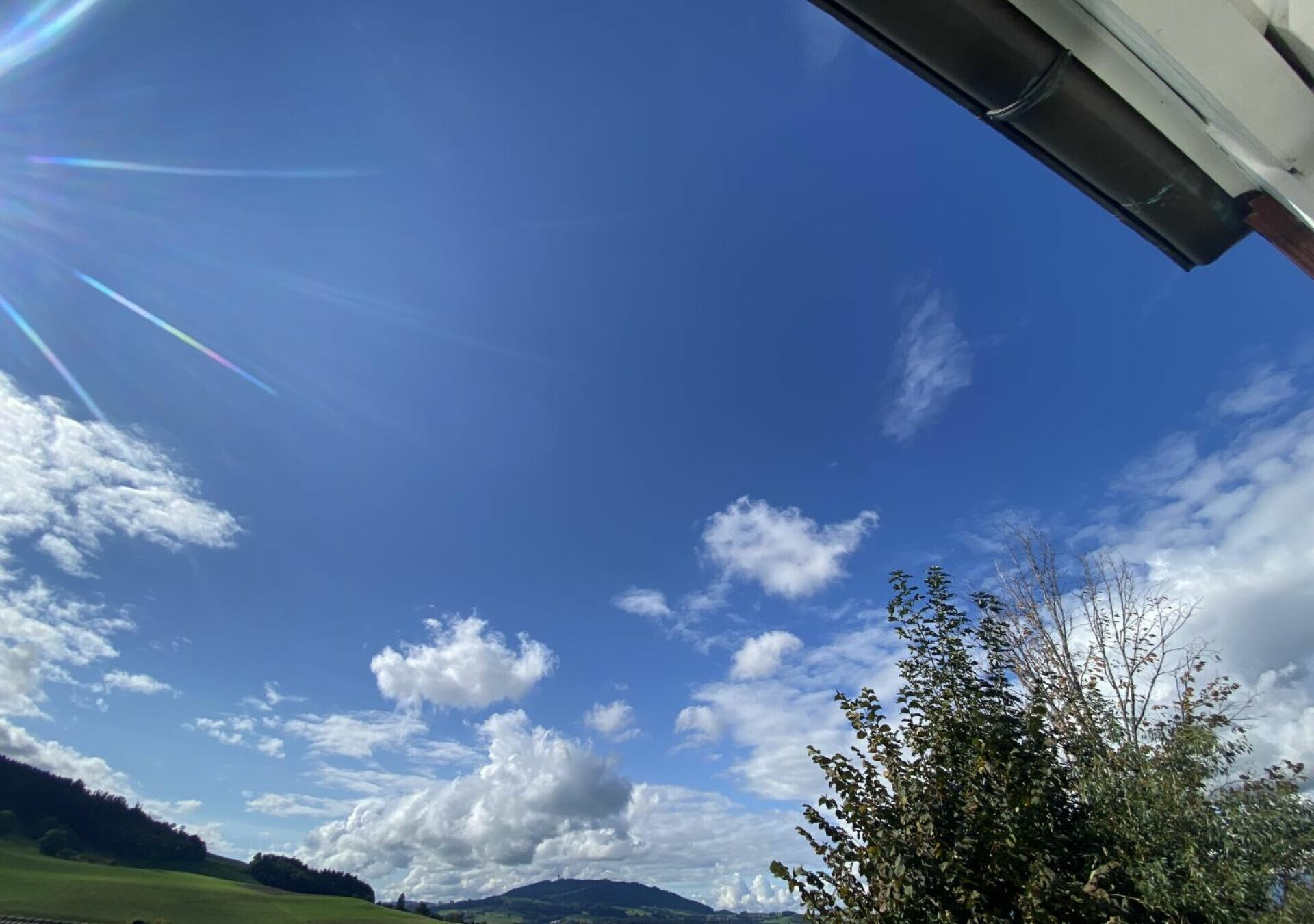 Blick in den blauen Himmel mit Landschaft am Horizont