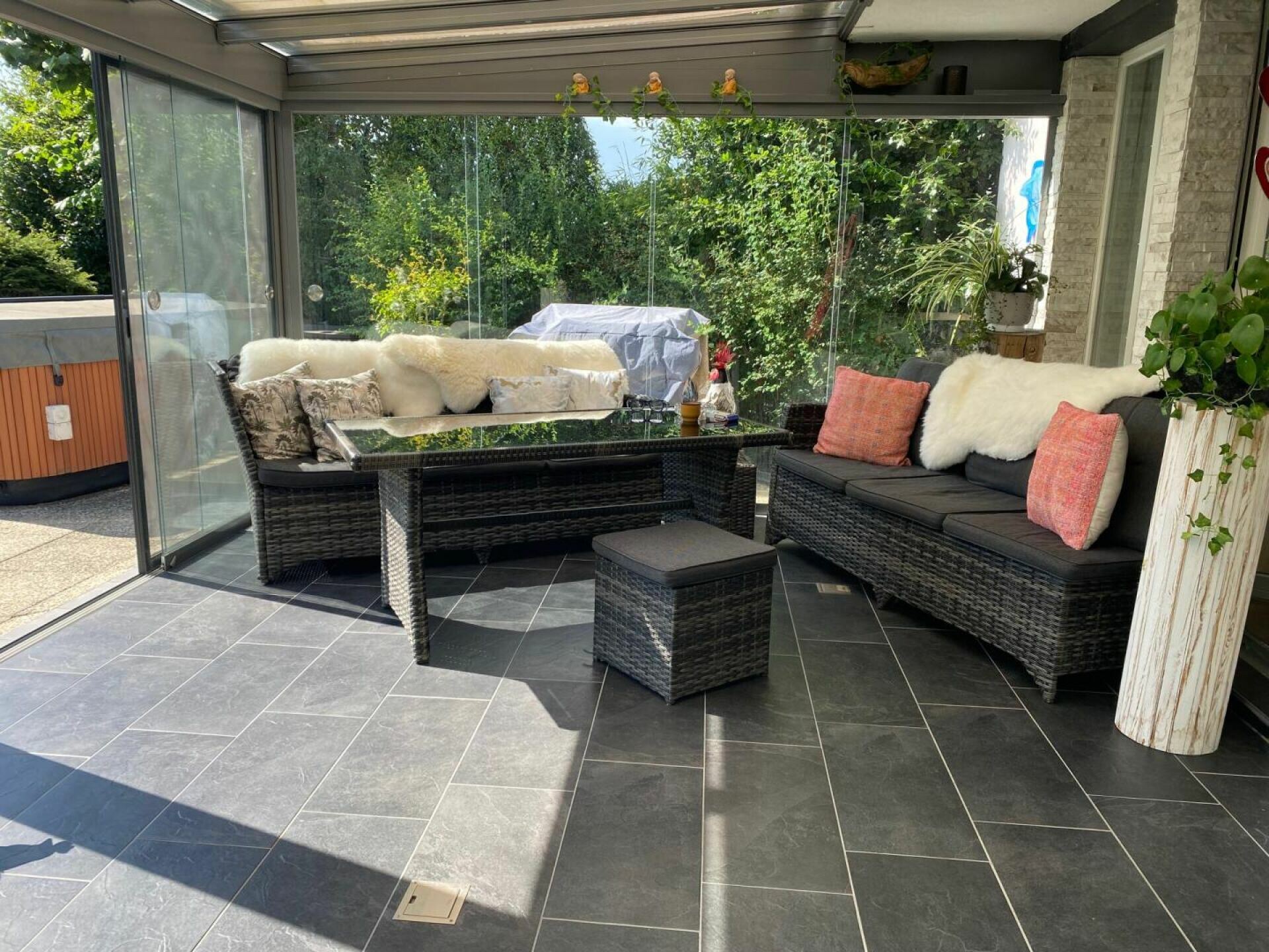 Verglaster Wintergarten mit Lounge-Möbeln