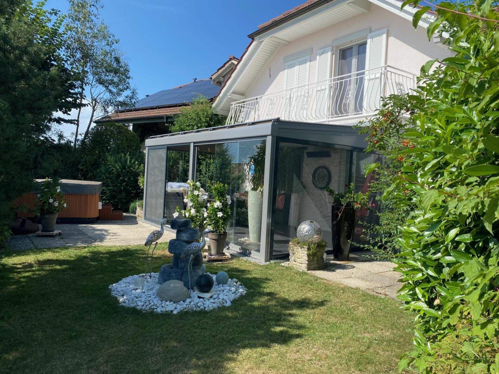 Gartenansicht eines Wohnhauses mit Wintergarten und Terrasse