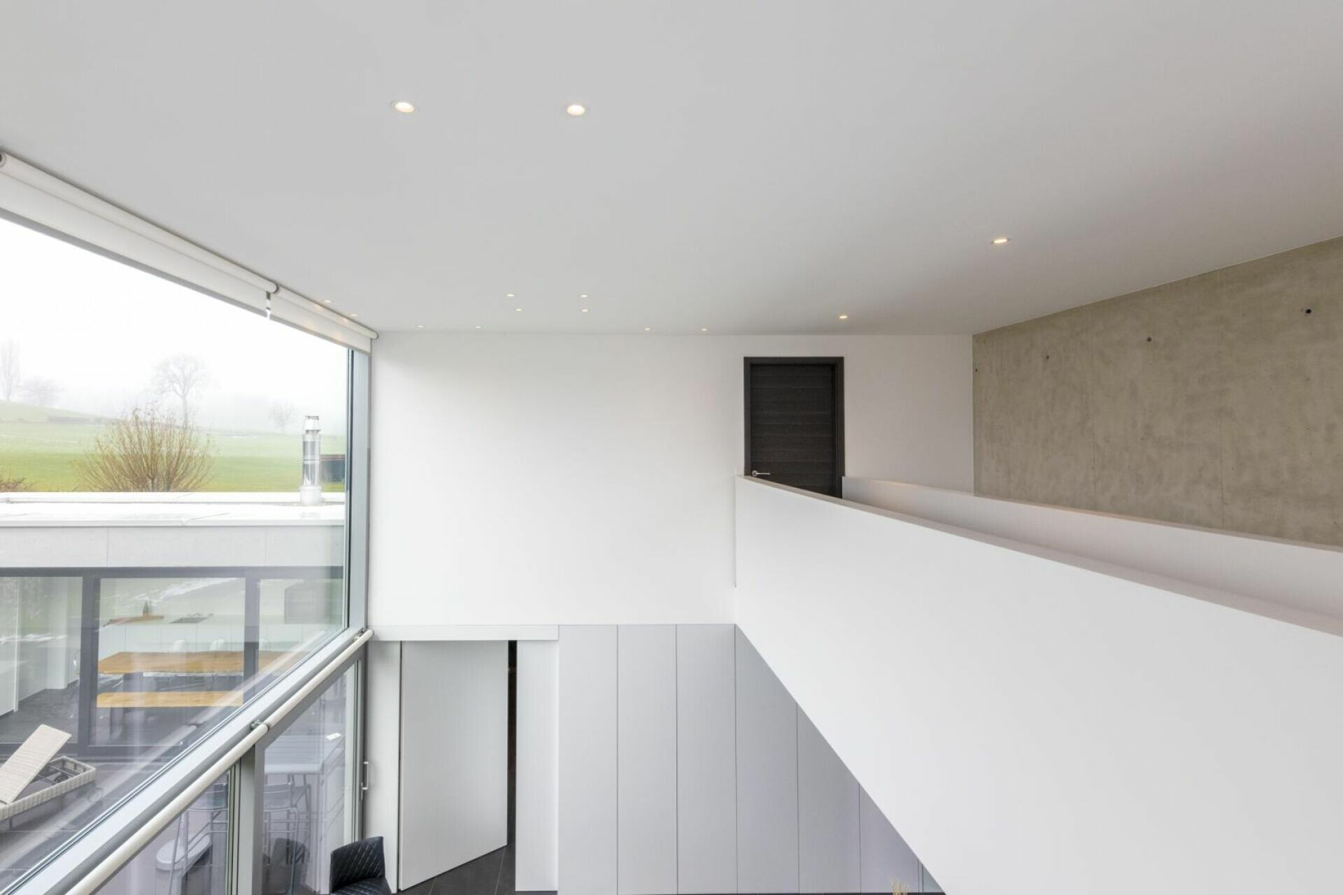 Modernes Treppenhaus mit Galerie und großem Fenster