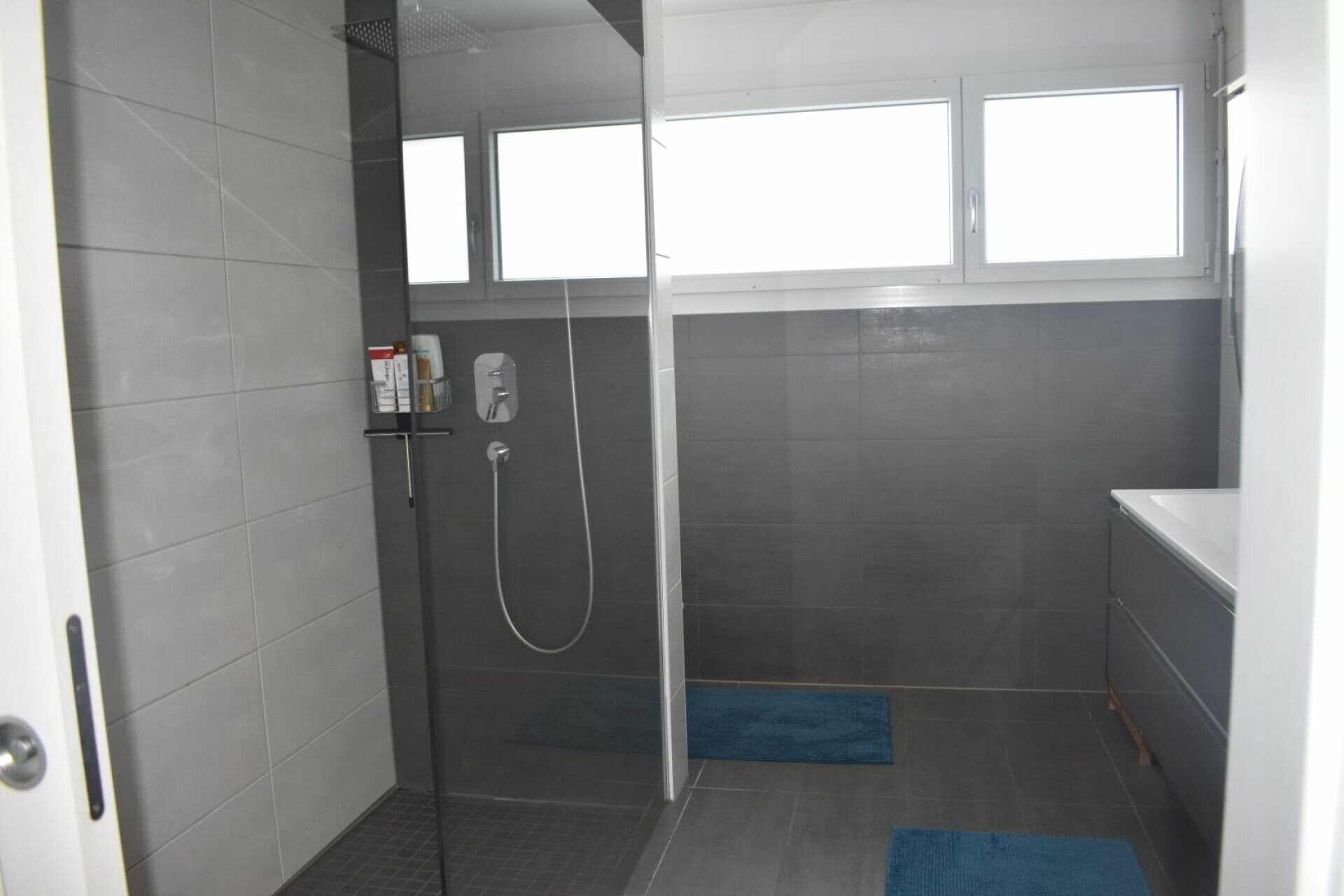Modernes Badezimmer mit grauen Fliesen und bodengleicher Dusche
