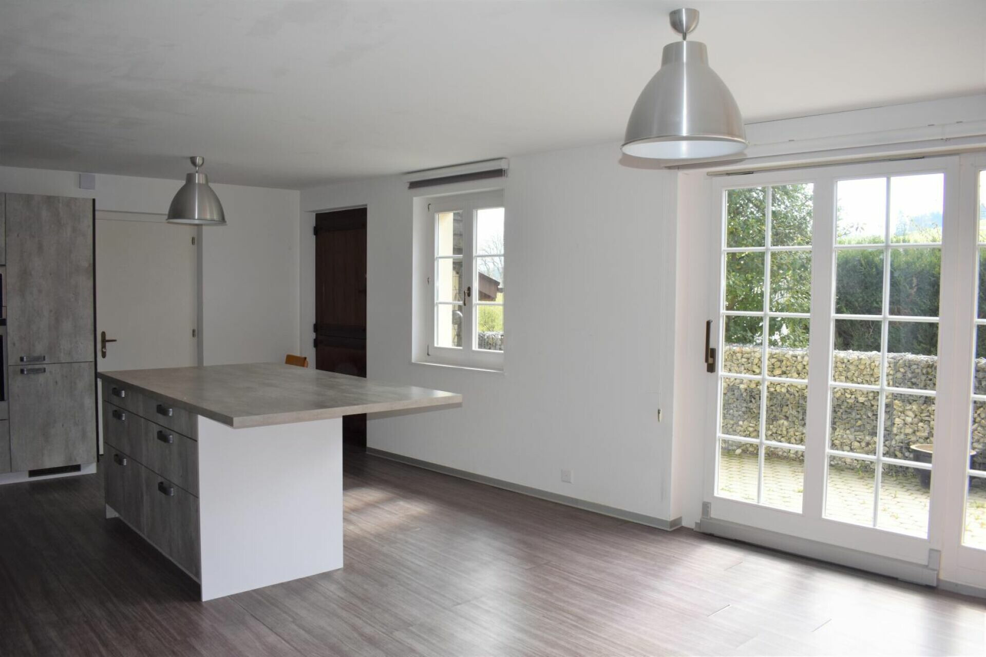 Offene Küche mit Kochinsel und Terrassenzugang