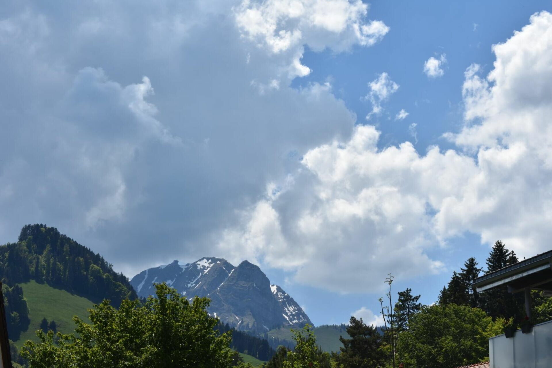 Berglandschaft mit Wolken und Gebäudeecke