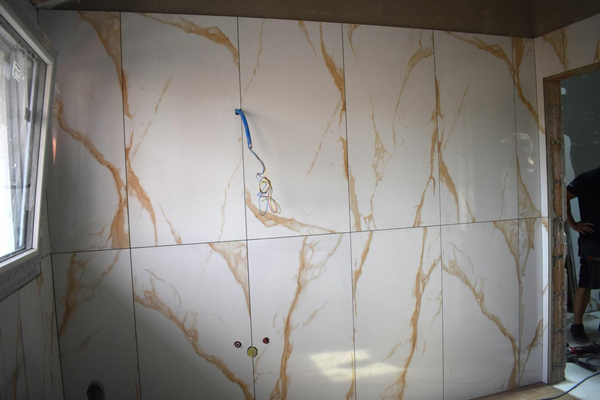 Innenraum mit großformatiger Wandverkleidung in Marmoroptik