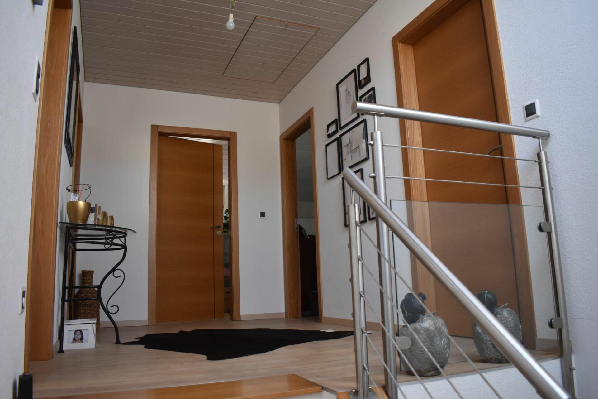 Heller Flur mit Holzdetails und Treppenaufgang