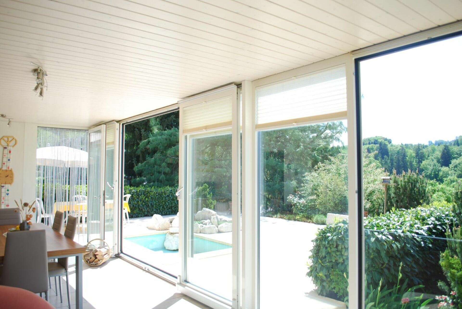 Heller Wohn-/Essbereich mit großflächiger Glasfront und Gartenblick