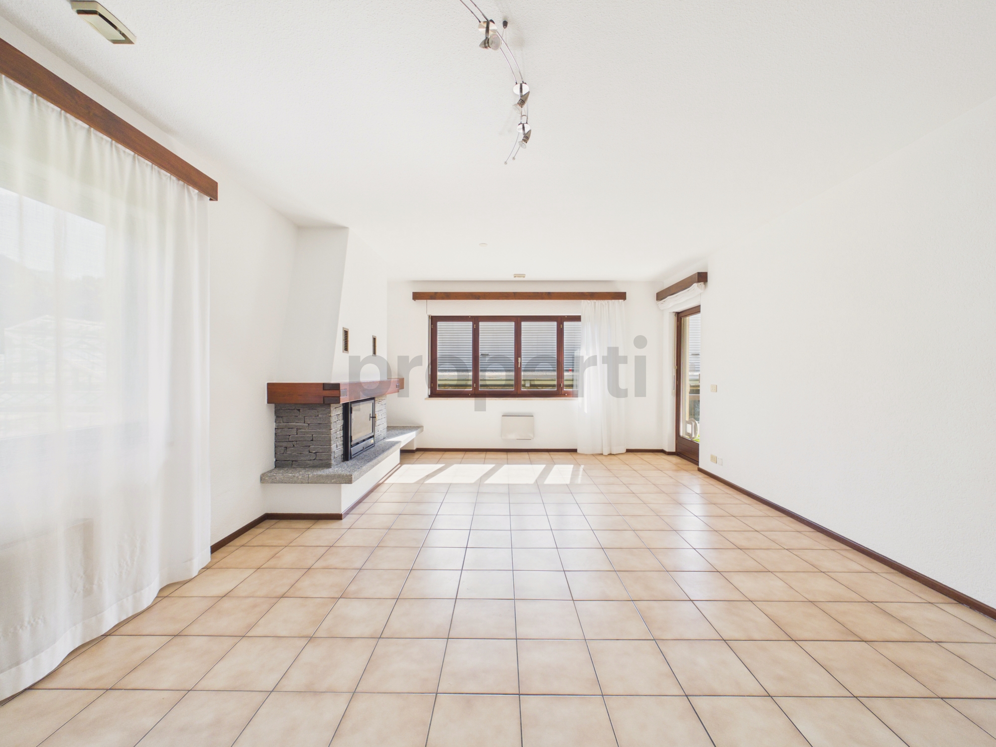 Heller Wohnraum mit Kamin und Fliesenboden