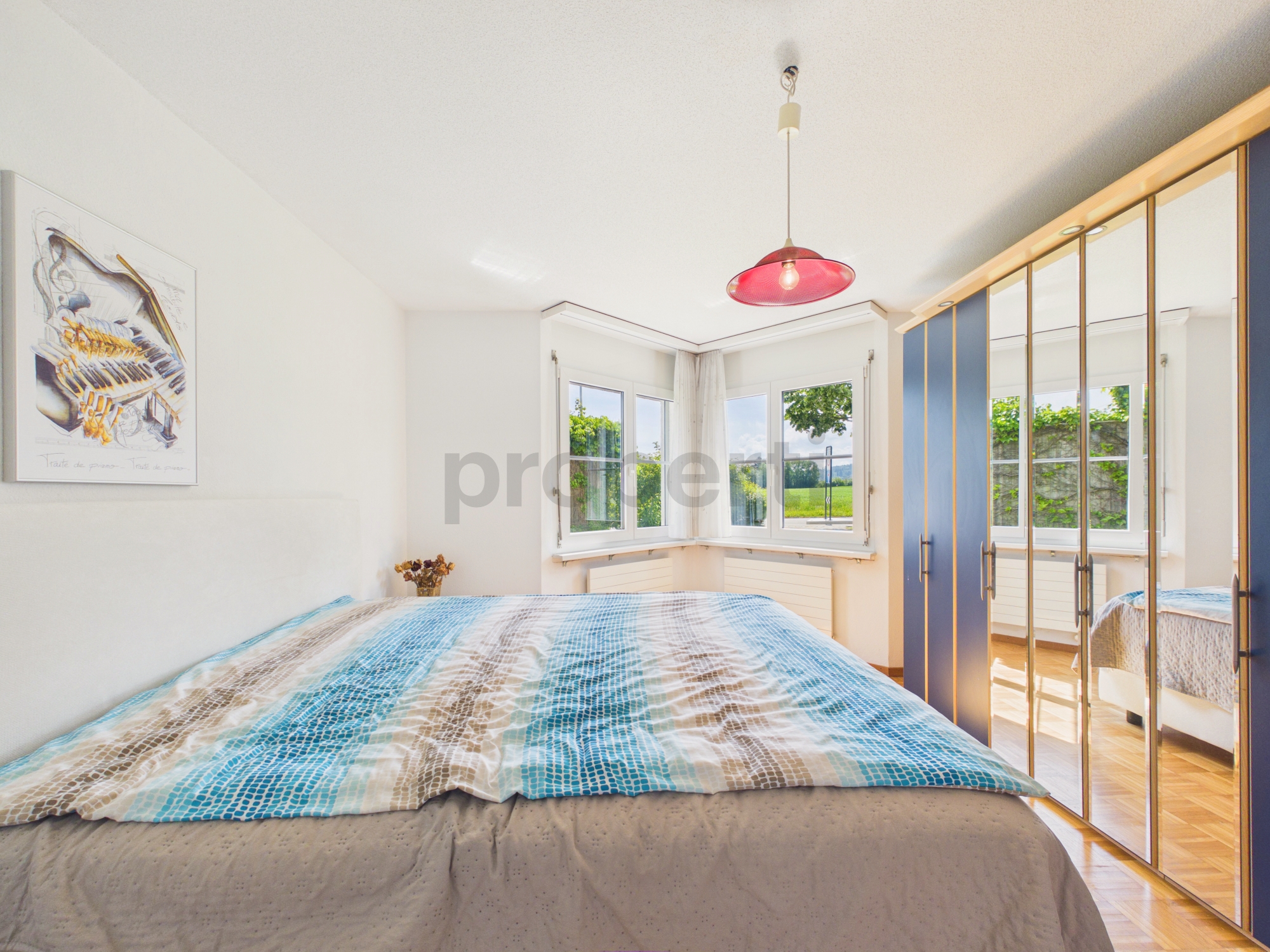 Helles Schlafzimmer mit großem Fenster und Kleiderschrank