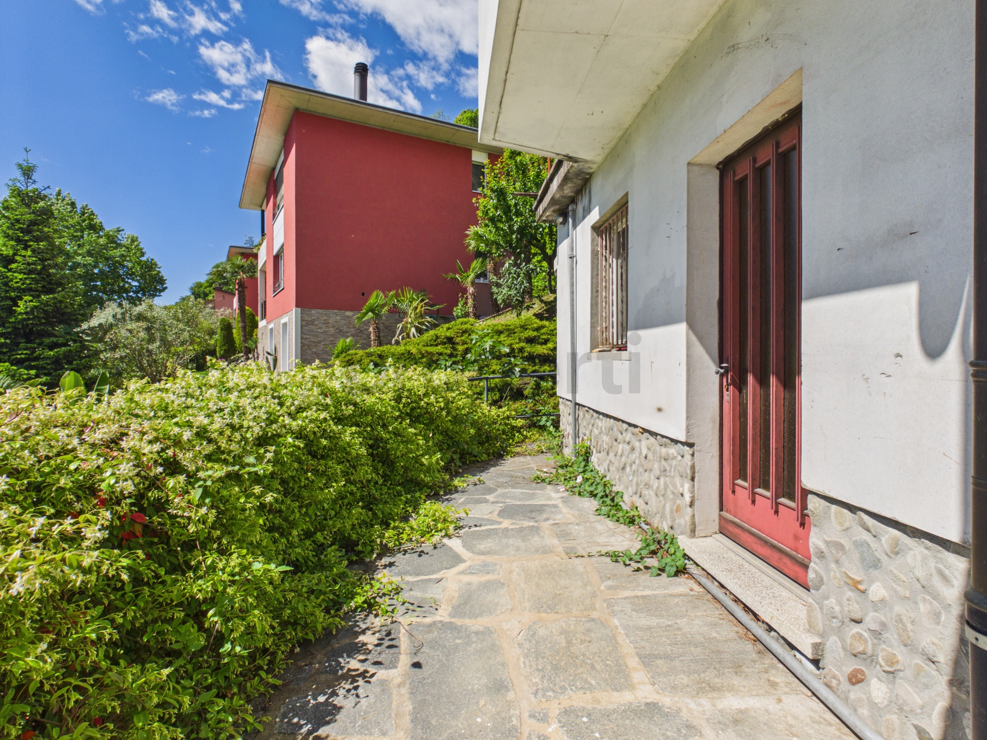 Außenansicht eines Wohngebäudes mit Gartenweg