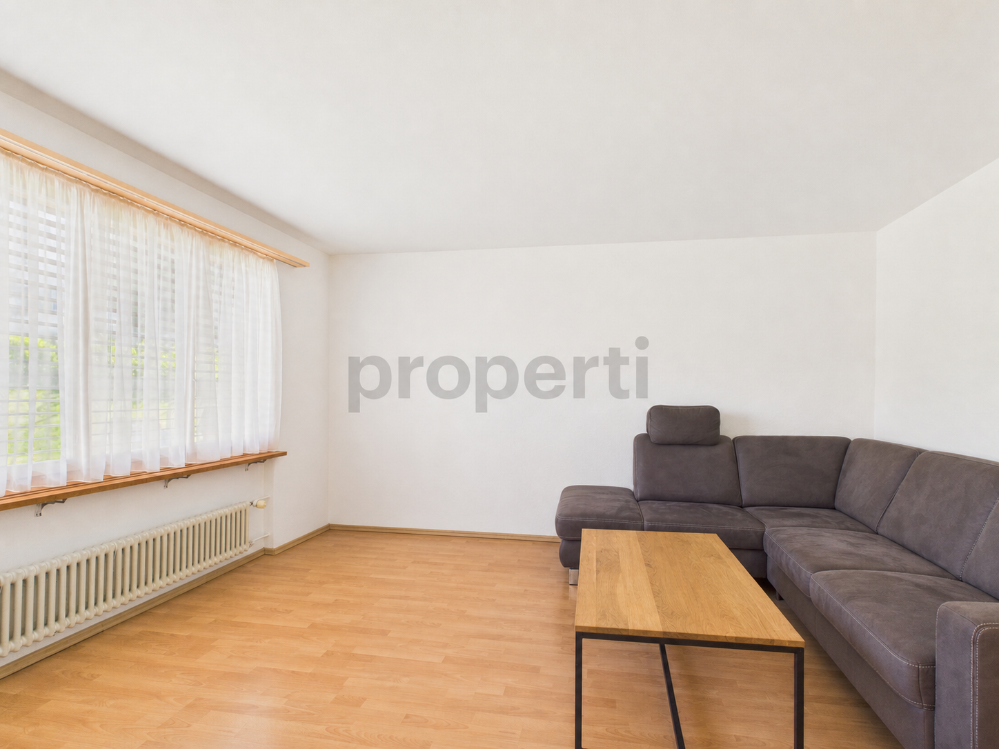 Heller Wohnraum mit Fenster, Sofa und Couchtisch