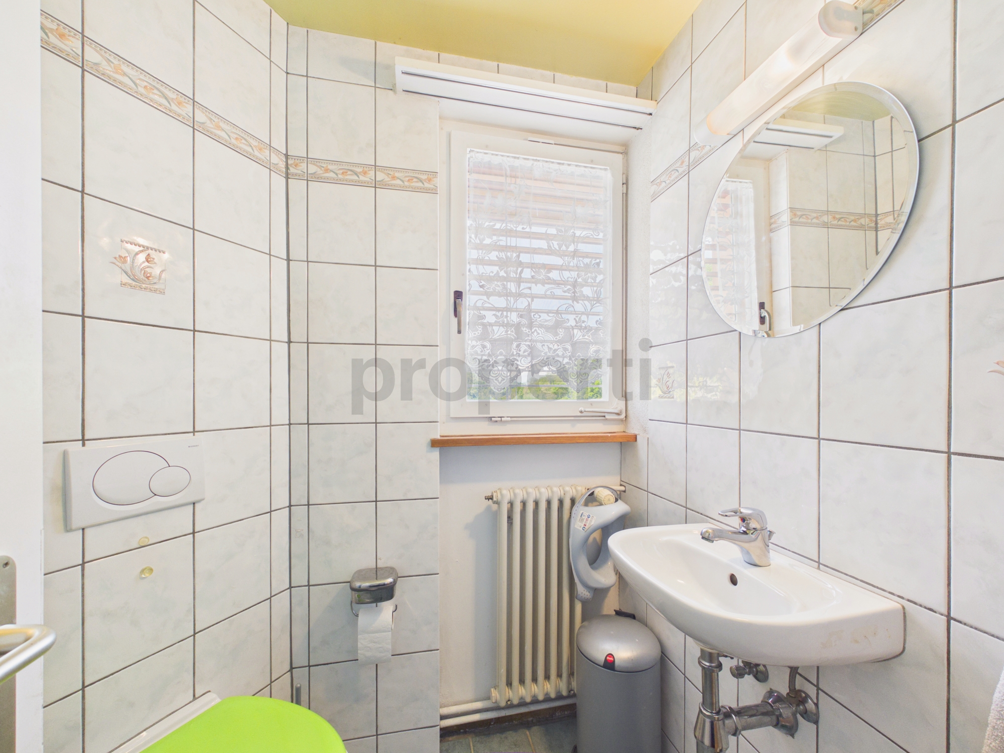 Kleines Badezimmer mit Fenster und Wandfliesen