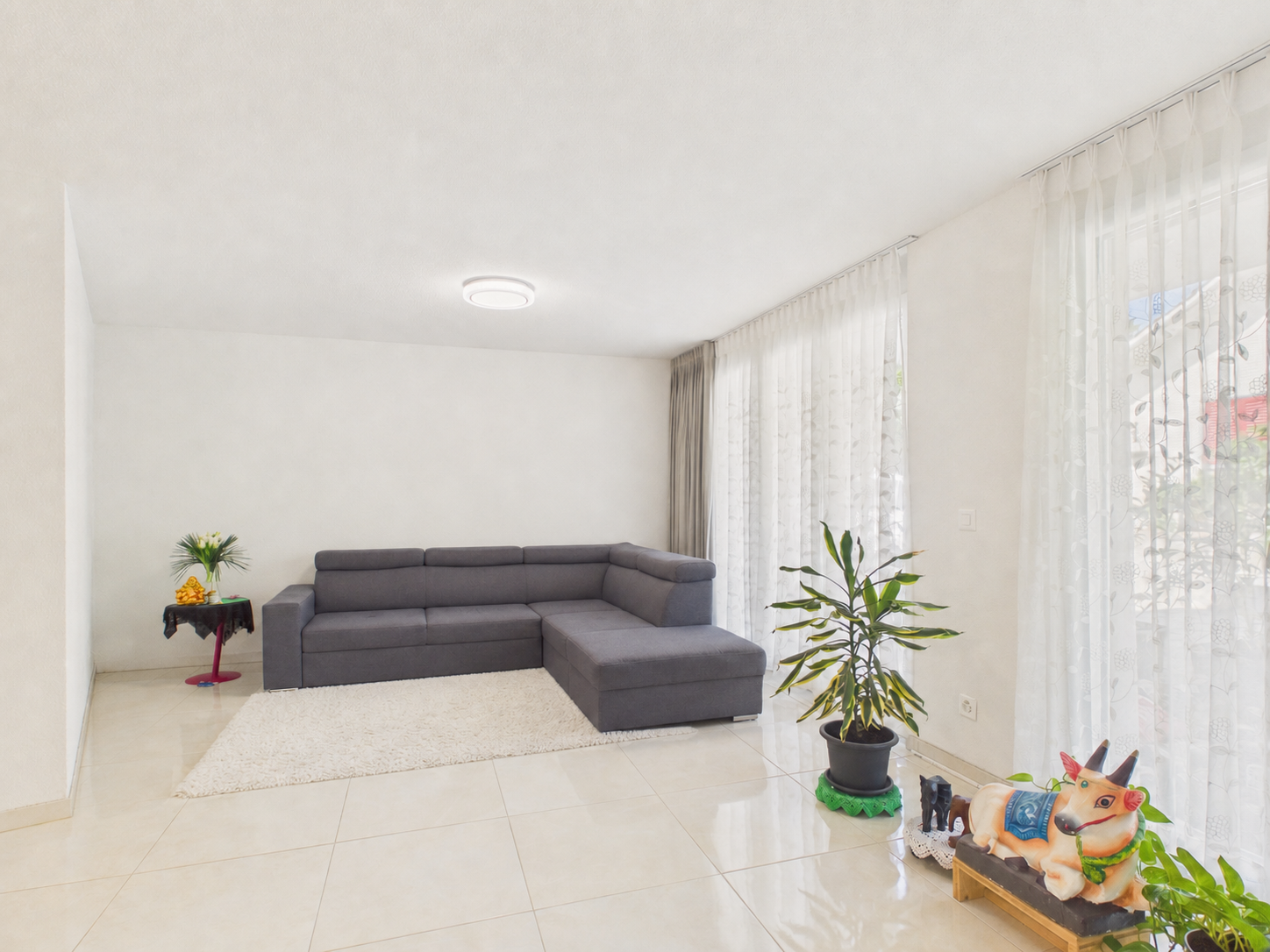 Heller Wohnraum mit Ecksofa und Pflanzen
