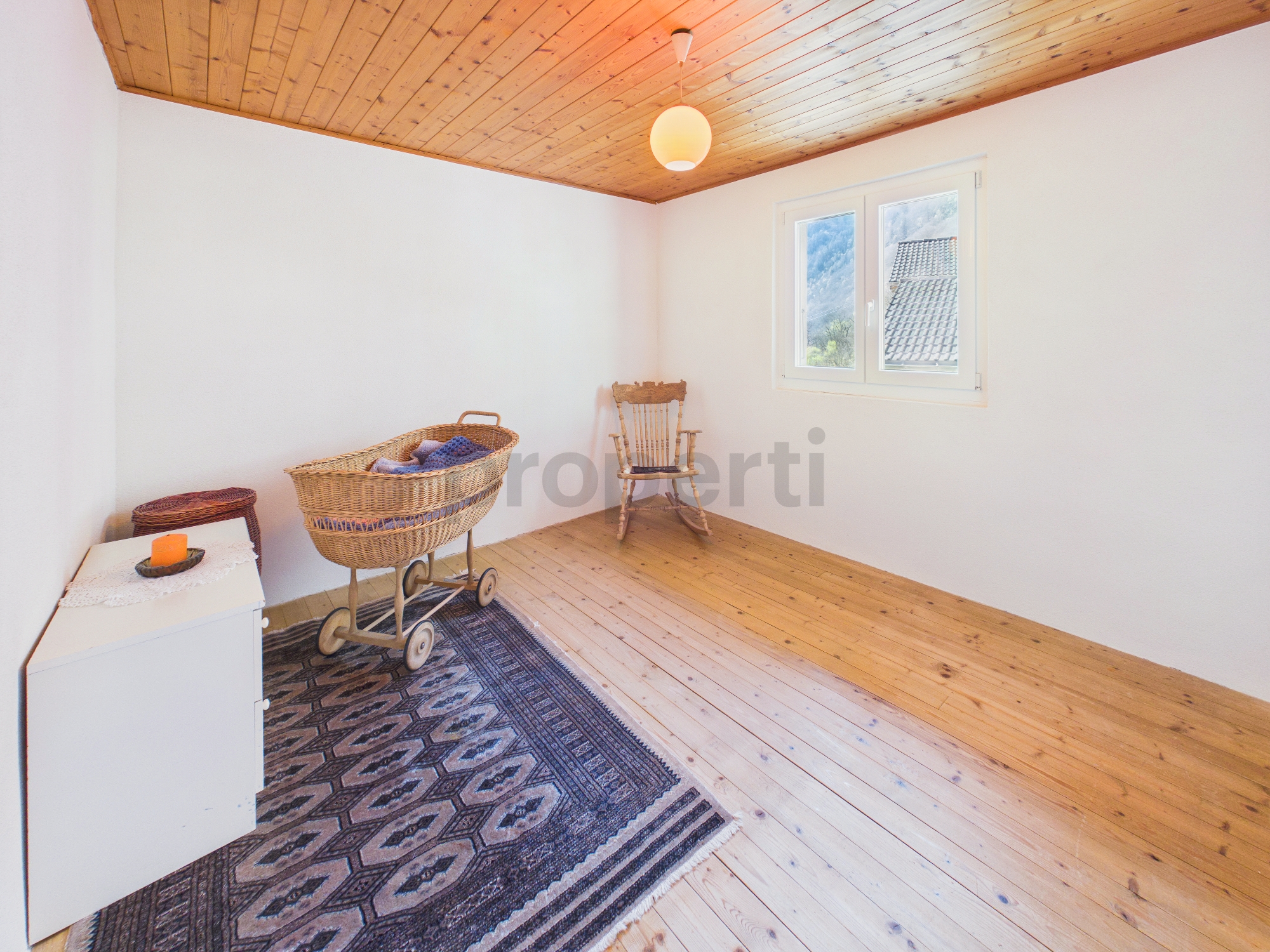 Helles, schlichtes Zimmer mit Holzdecke und Kinderwagen