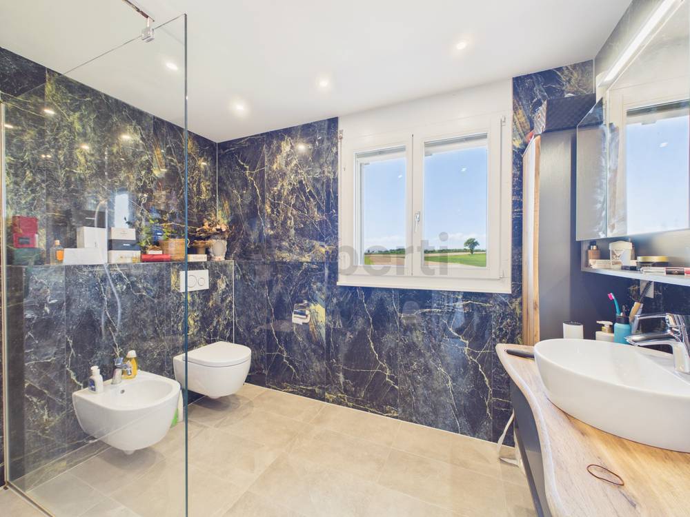 Modernes Badezimmer mit Natursteinoptik und Doppelbereich