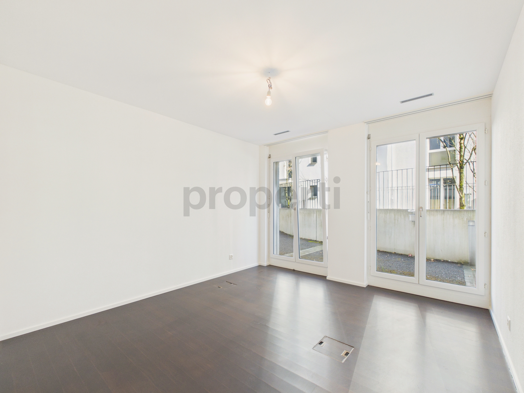Helles, leeres Zimmer mit großen Fenstertüren