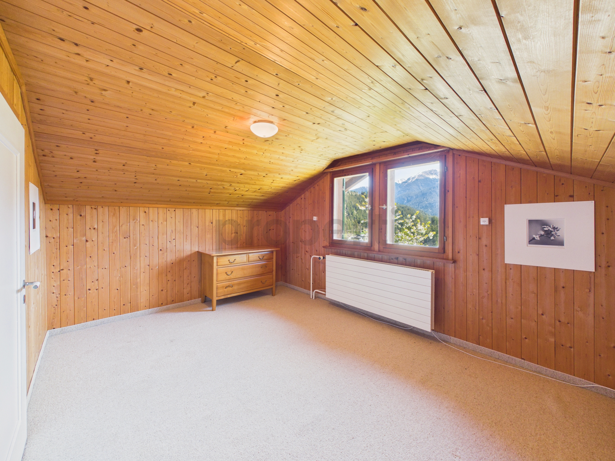 Dachzimmer mit Holzvertäfelung und Bergblick