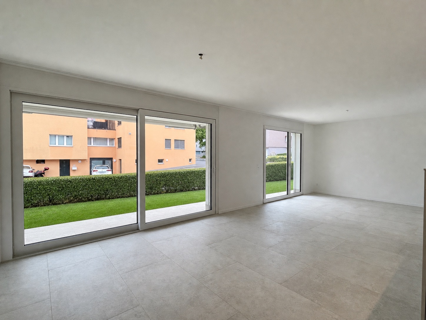 Heller leerer Wohnraum mit großen Glasfronten