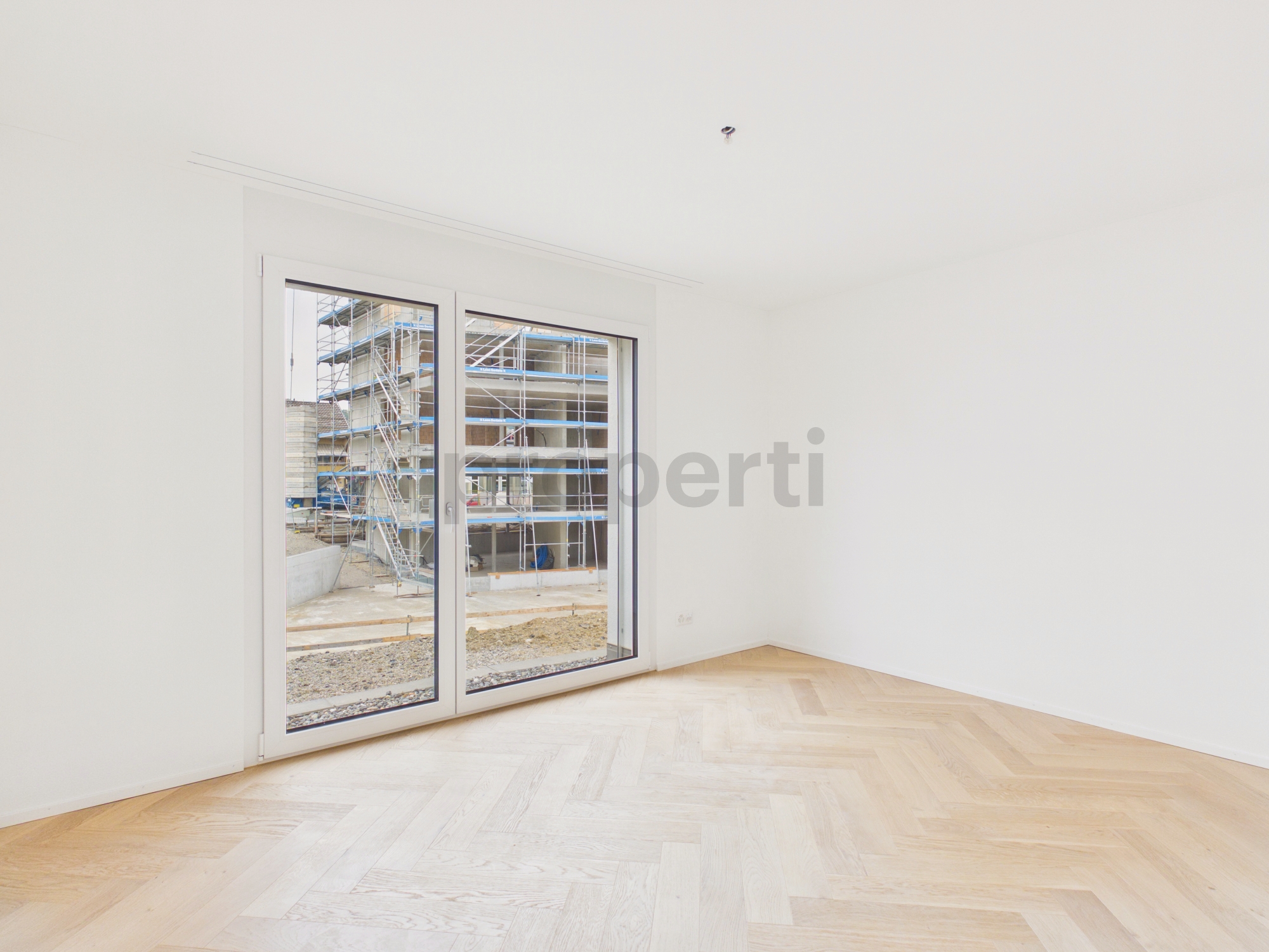 Heller, leerer Neubau-Raum mit großem Fenster