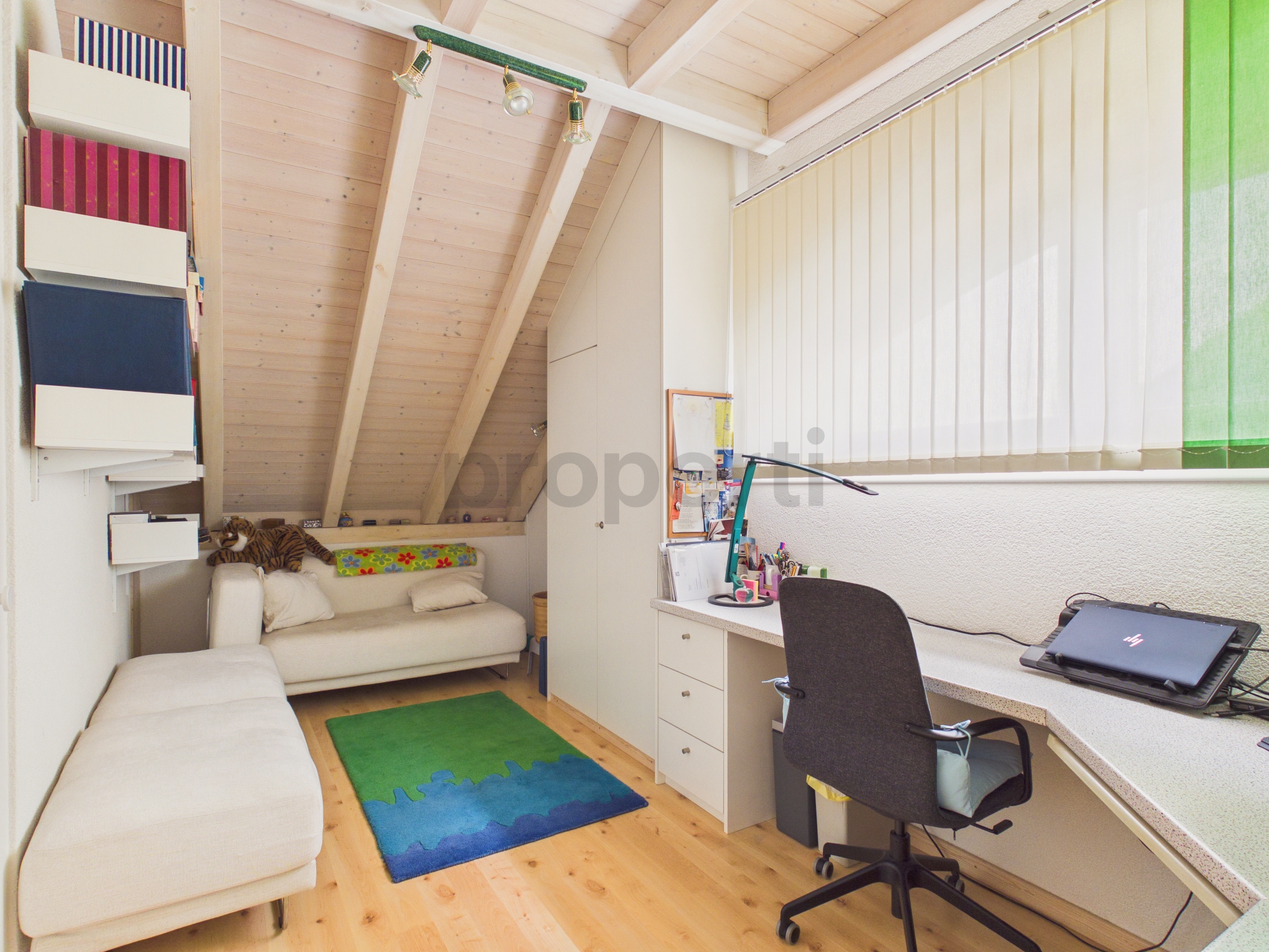 Helles Dachzimmer mit Arbeitsbereich und Sitzgelegenheit