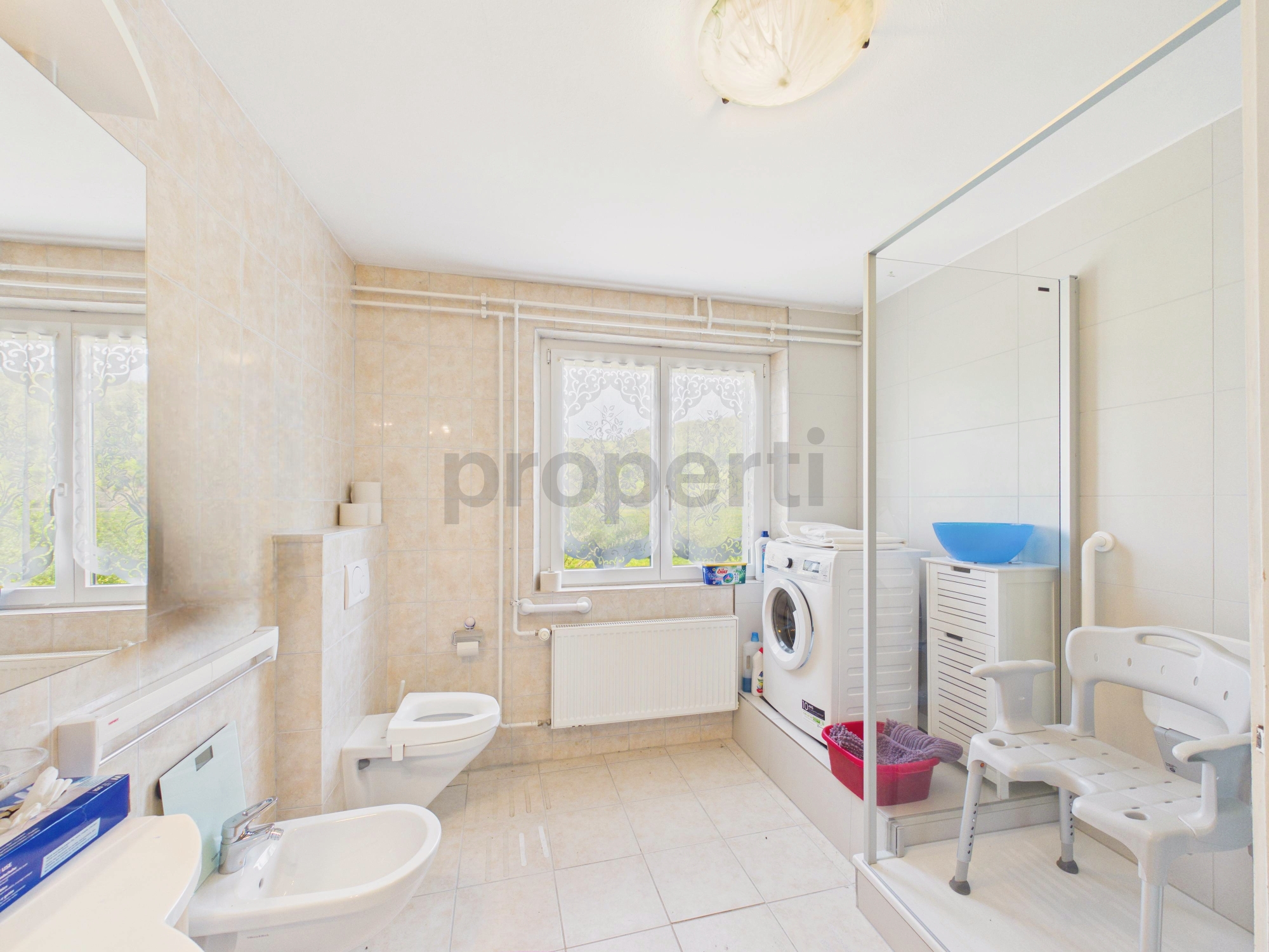 Helles Badezimmer mit Waschmaschine und Toilette
