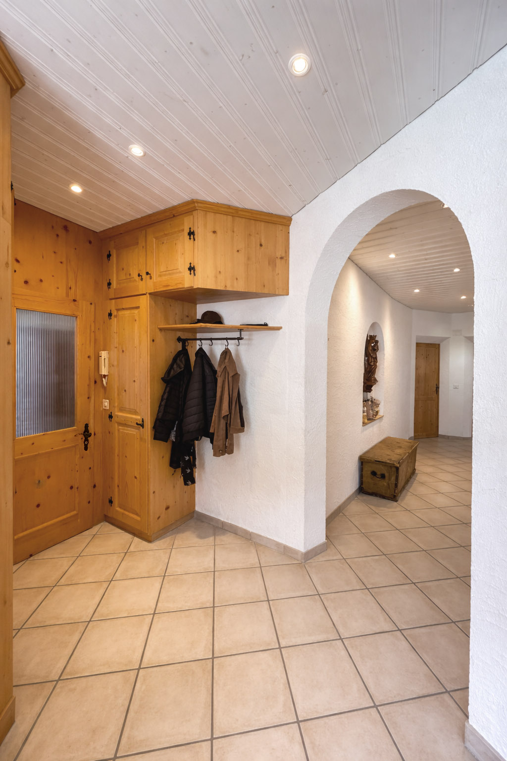 Flur mit Holzschrank und Rundbogen