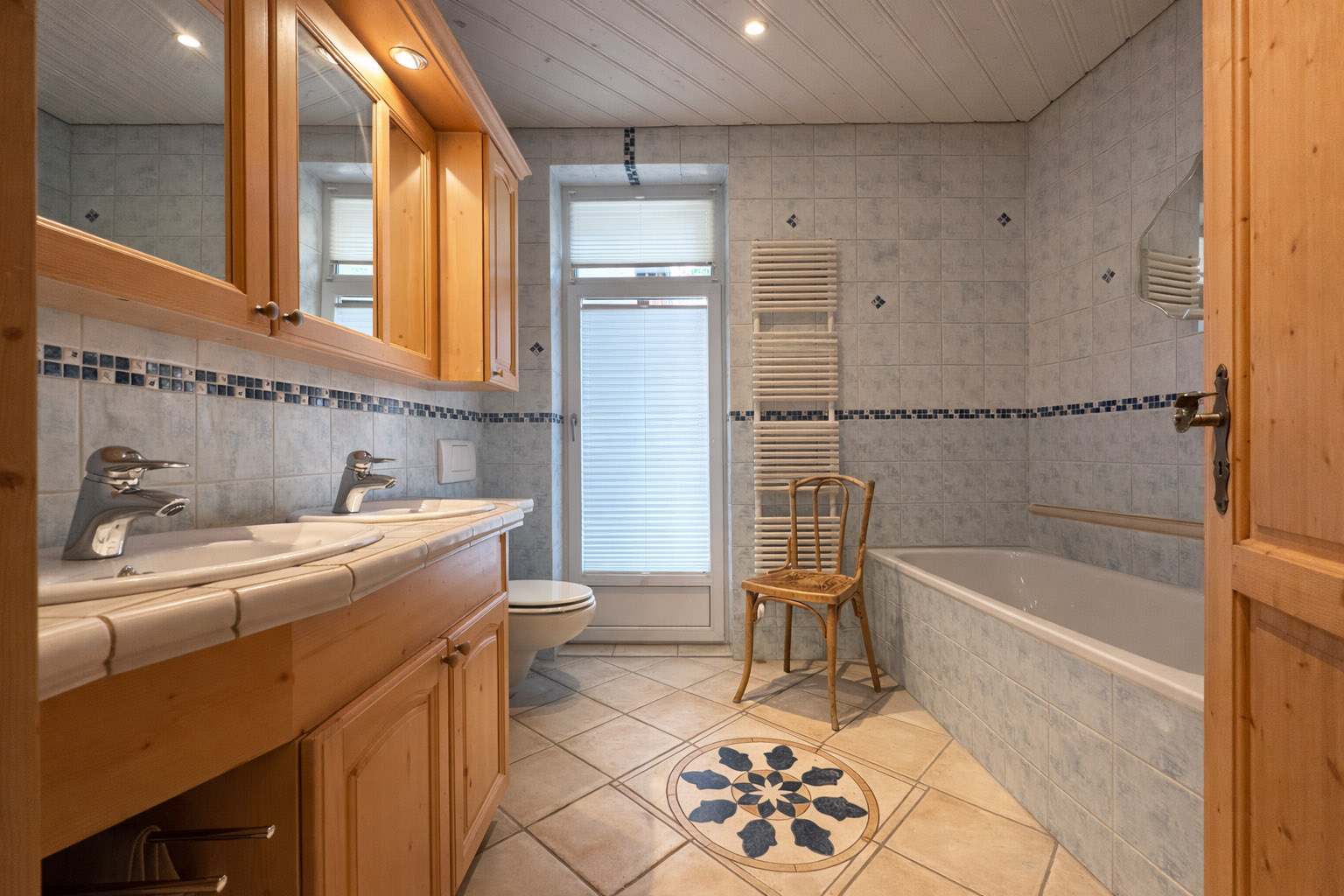 Badezimmer mit Doppelwaschtisch und Badewanne