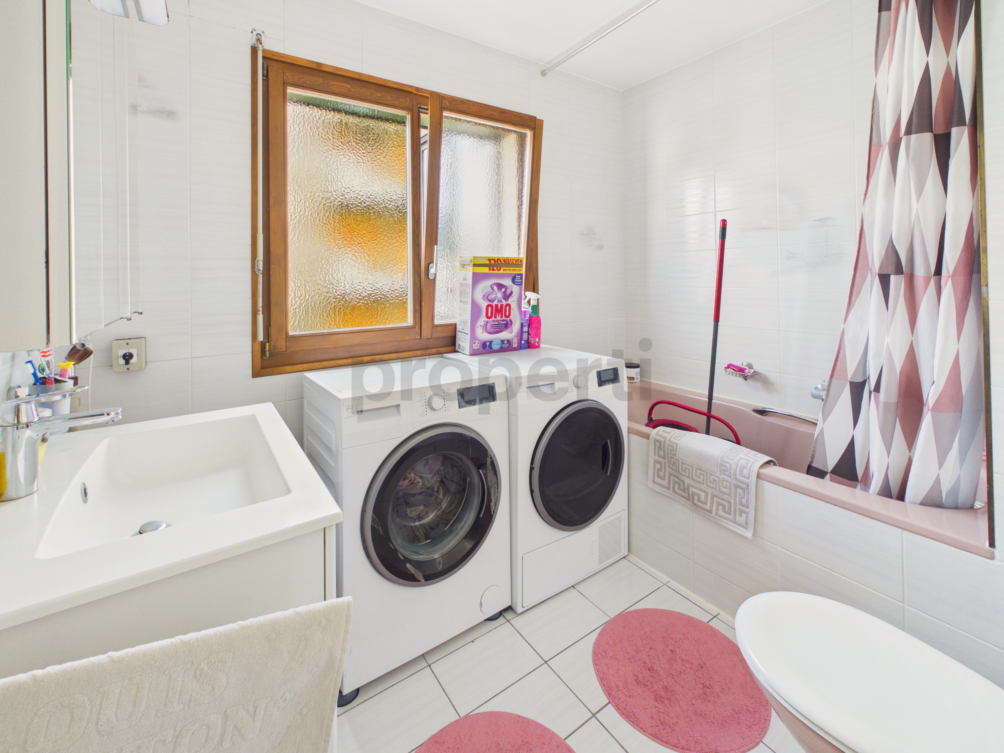 Badezimmer mit Waschmaschine und Badewanne