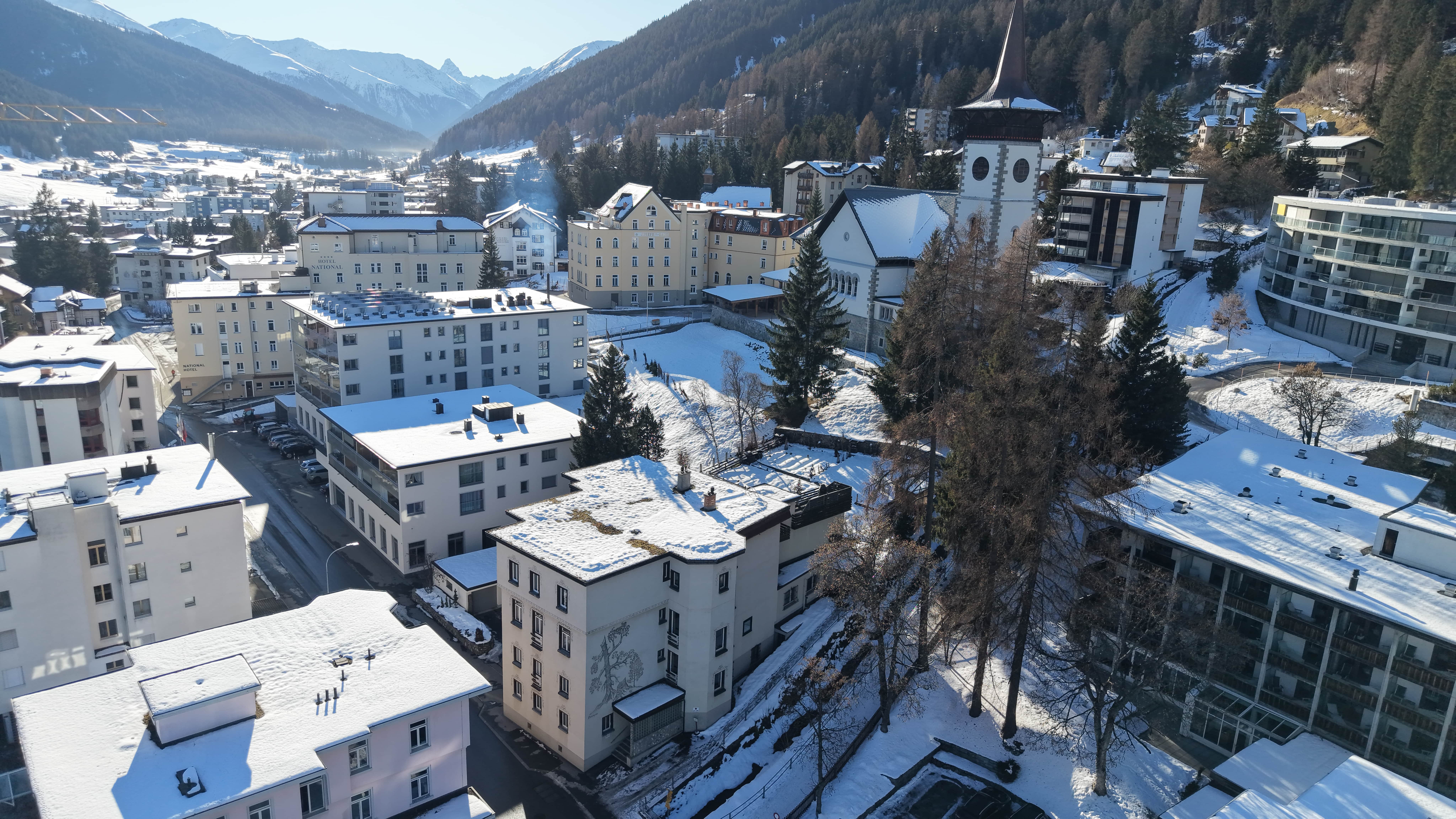 Schneebedeckte Alpenstadt mit Bergpanorama