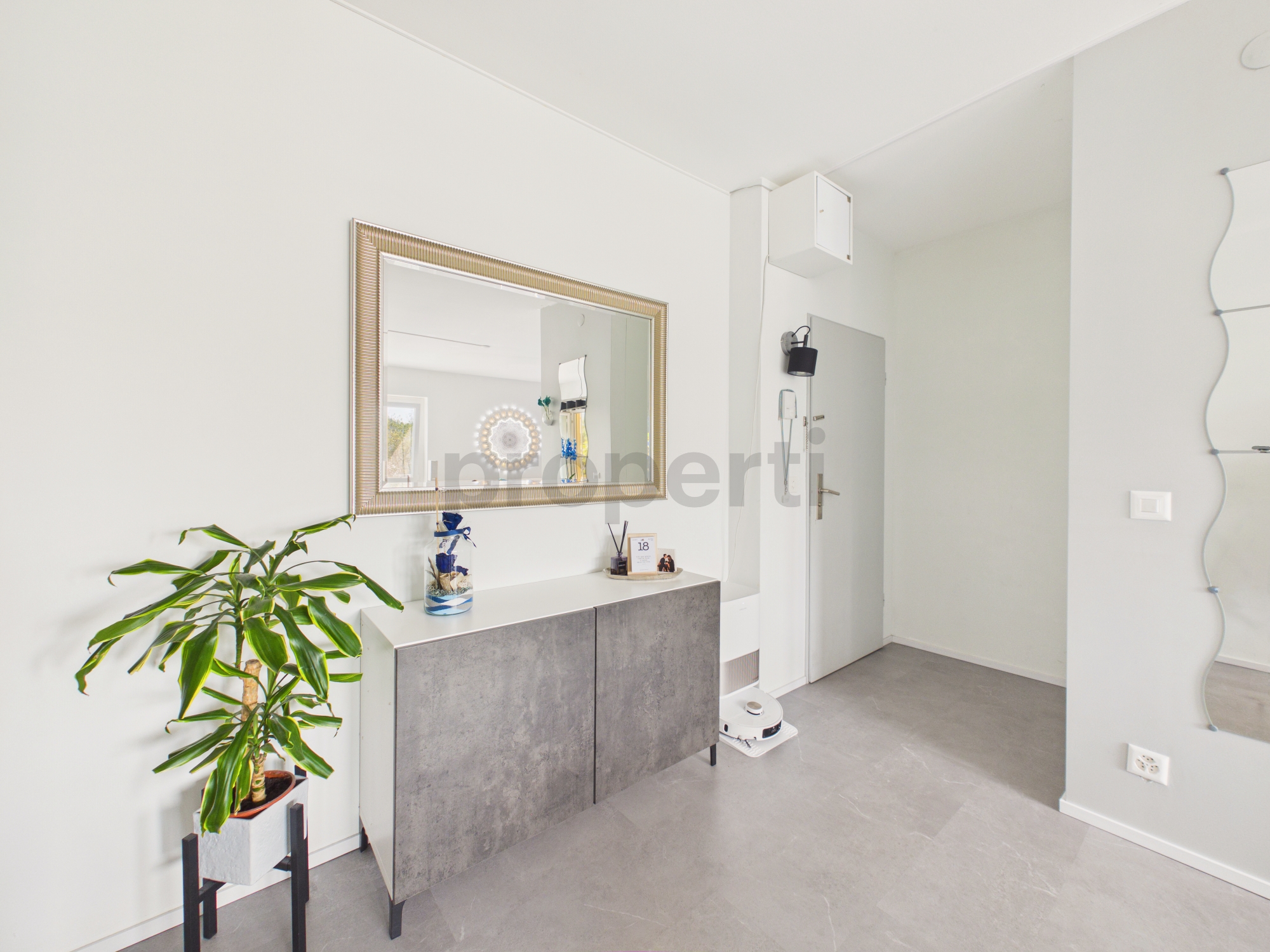 Heller Eingangsbereich mit Sideboard und Spiegel