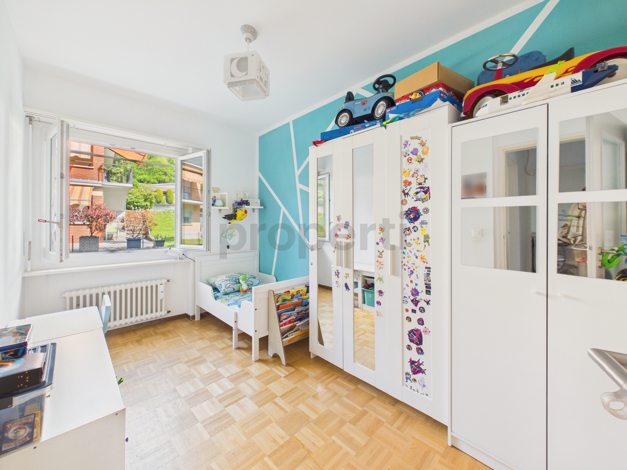 Helles Kinderzimmer mit Kleiderschrank und Fenster
