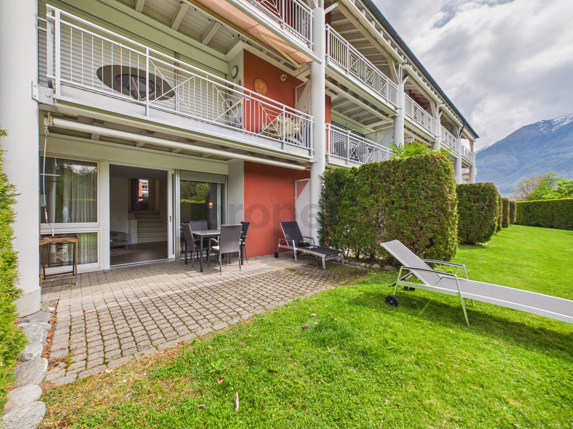 Außenansicht einer Wohnanlage mit Terrasse und Garten