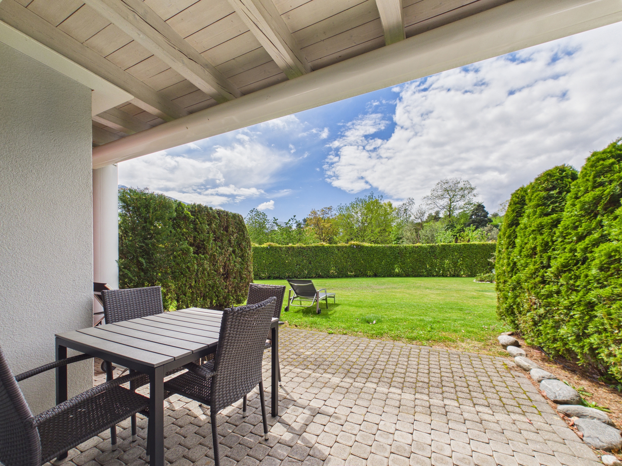 Überdachte Terrasse mit Gartenblick