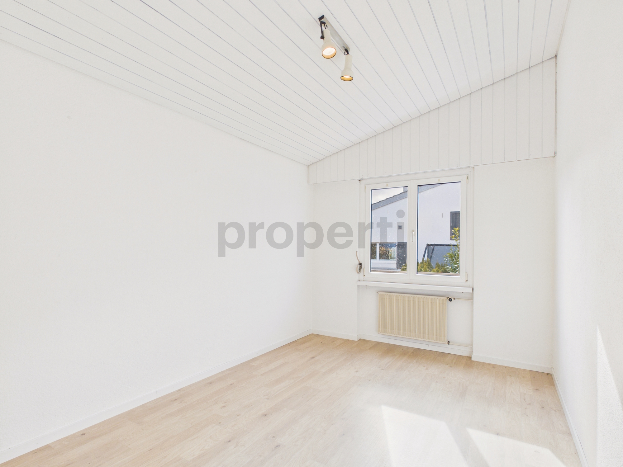 Heller leerer Raum mit Dachschräge und Fenster