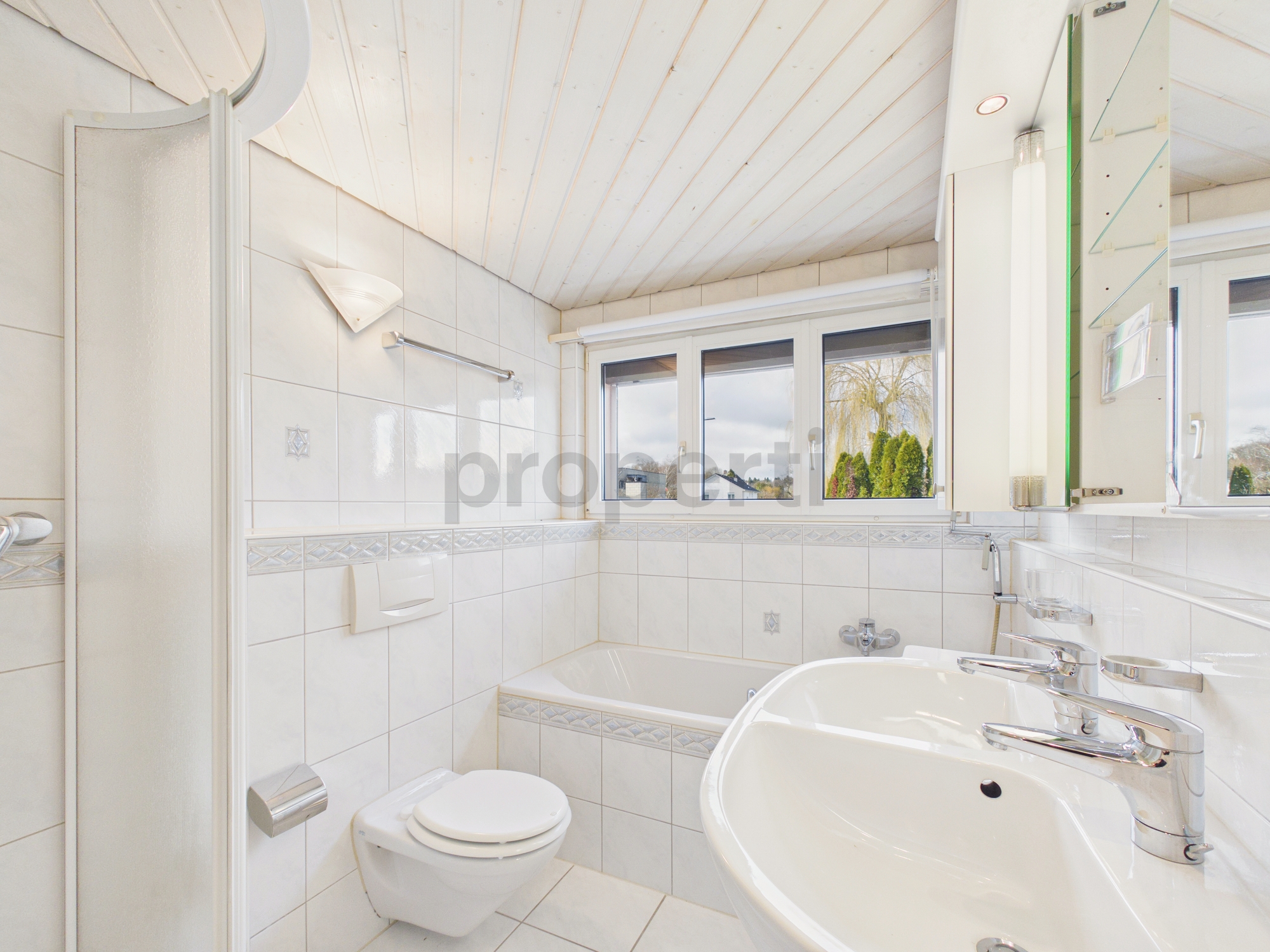 Helles Badezimmer mit Badewanne, Dusche und Fenster