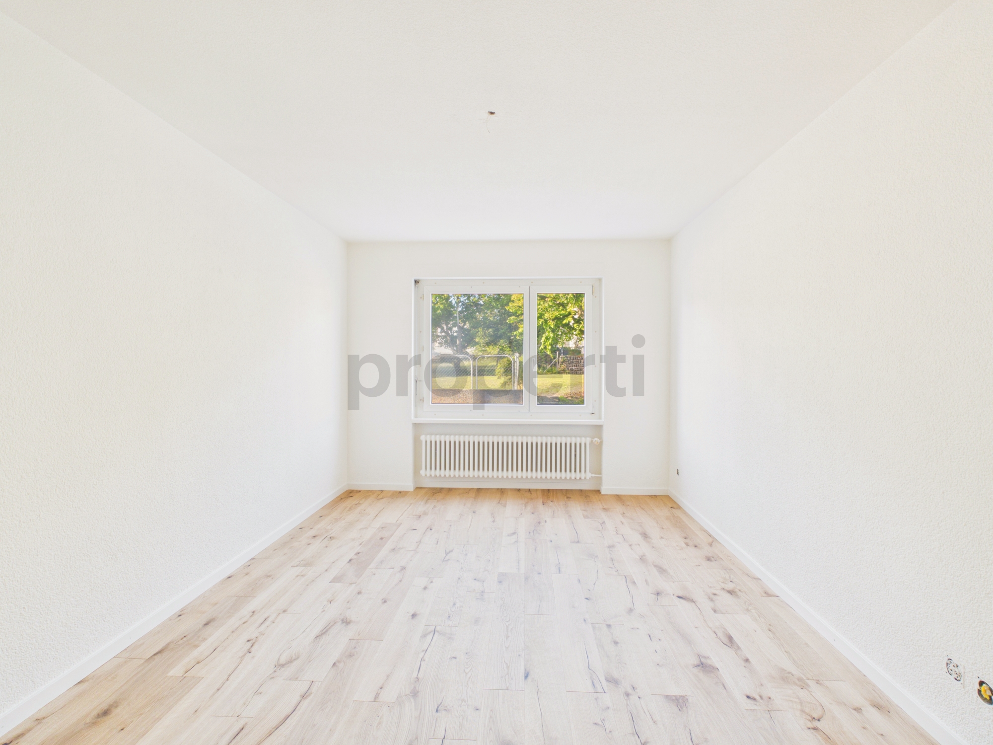 Heller leerer Raum mit Fenster und Heizkörper