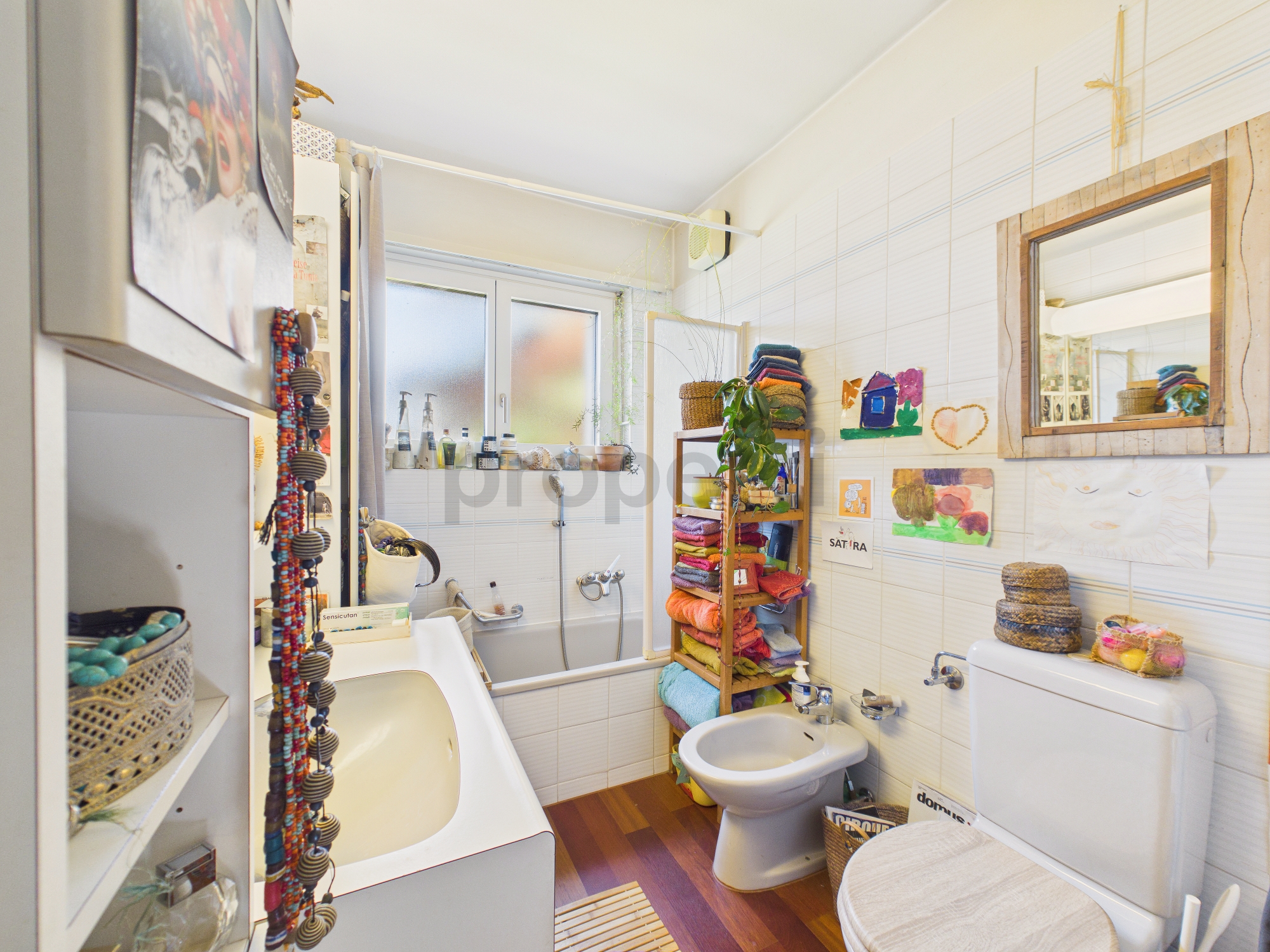 Kleines, helles Badezimmer mit Badewanne und WC