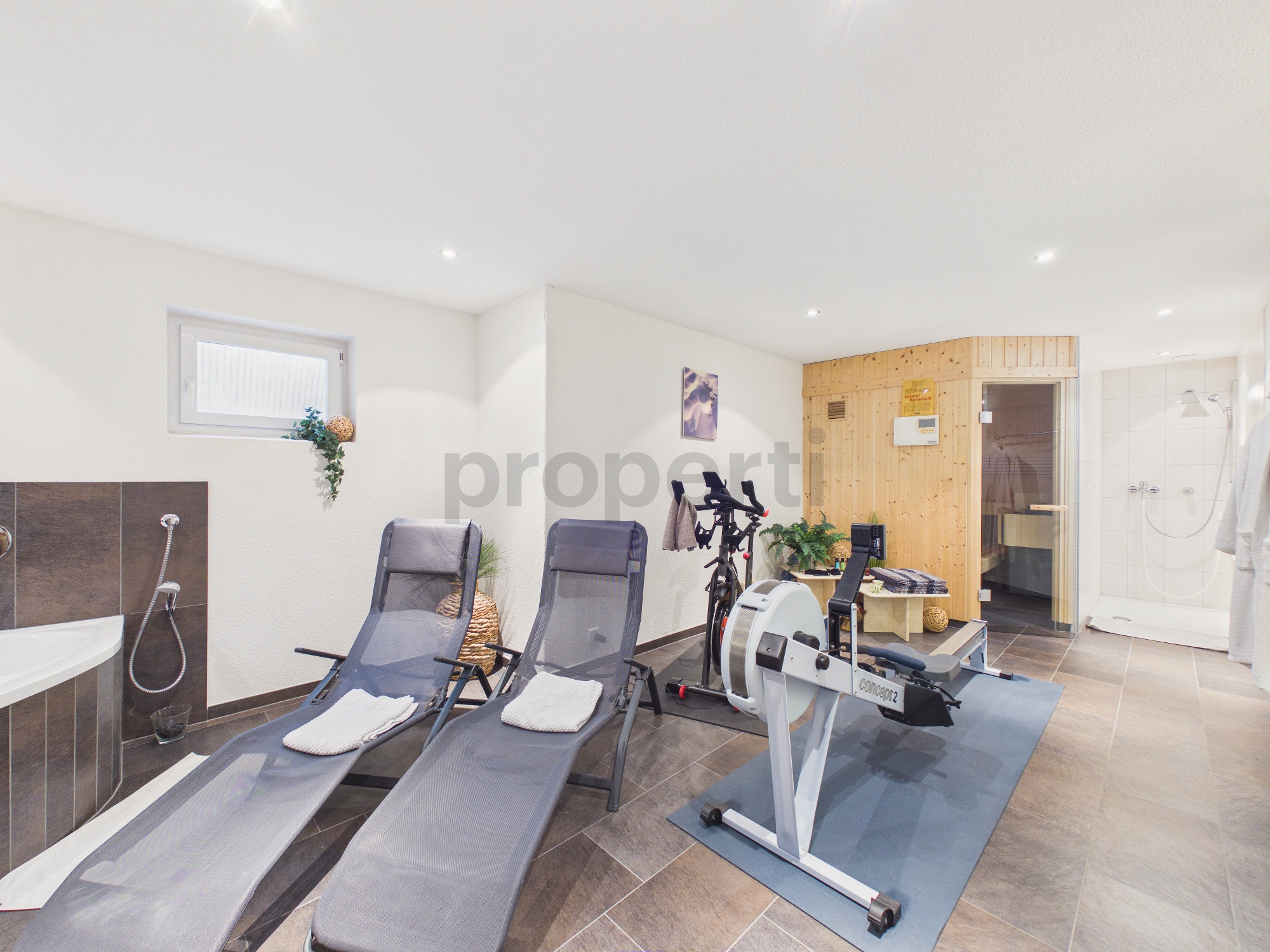 Wellnessraum mit Sauna und Fitnessbereich