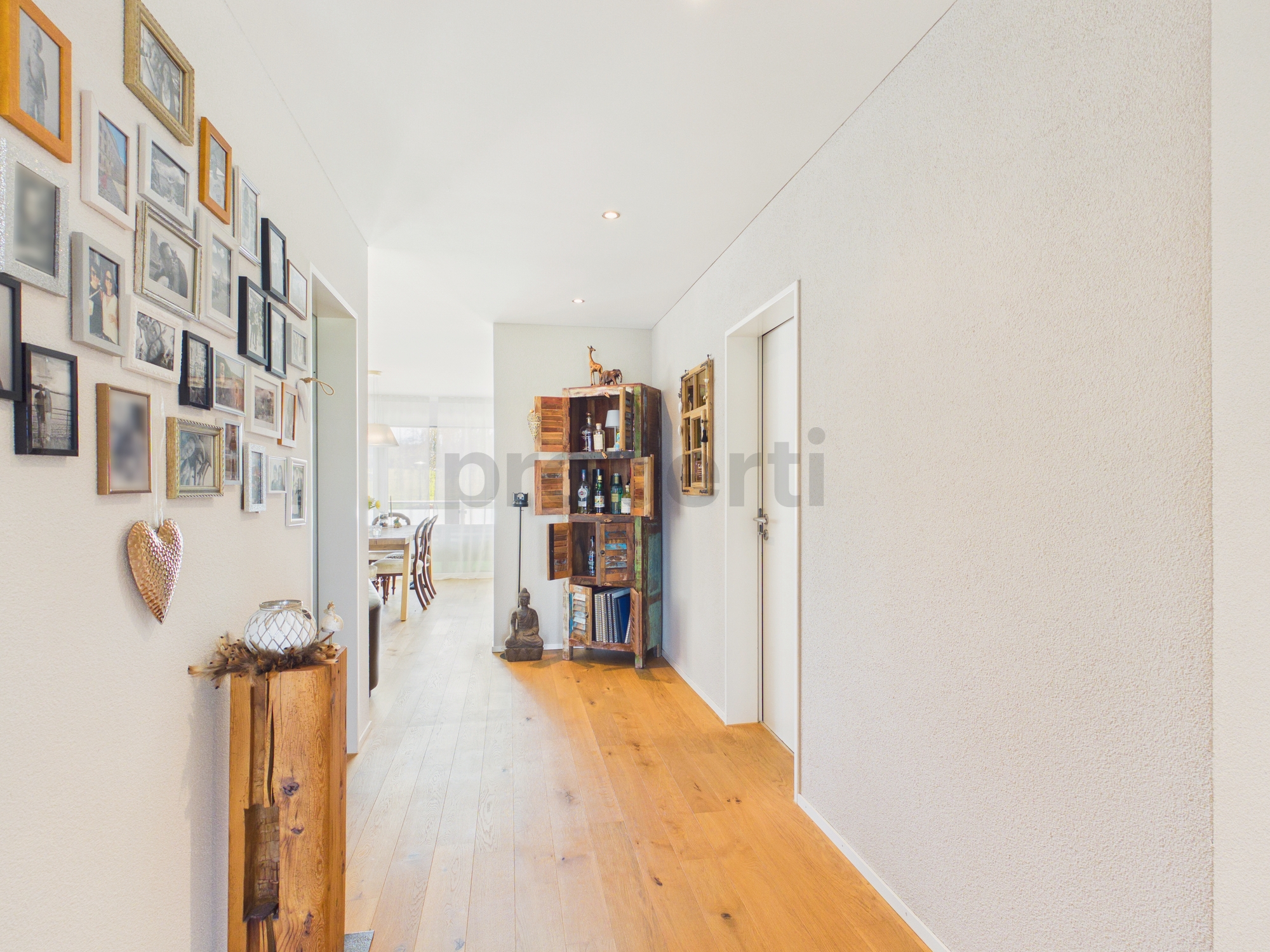Heller Flur mit Holzboden und Bildergalerie