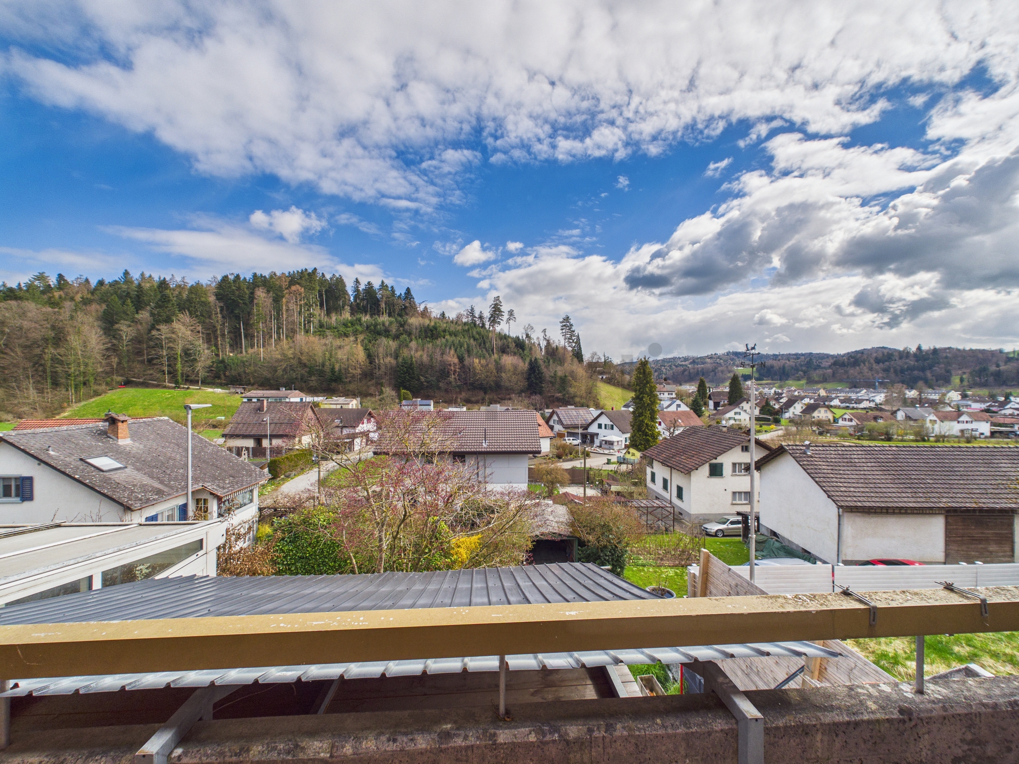 Blick über ein Wohngebiet mit Hügeln und Himmel