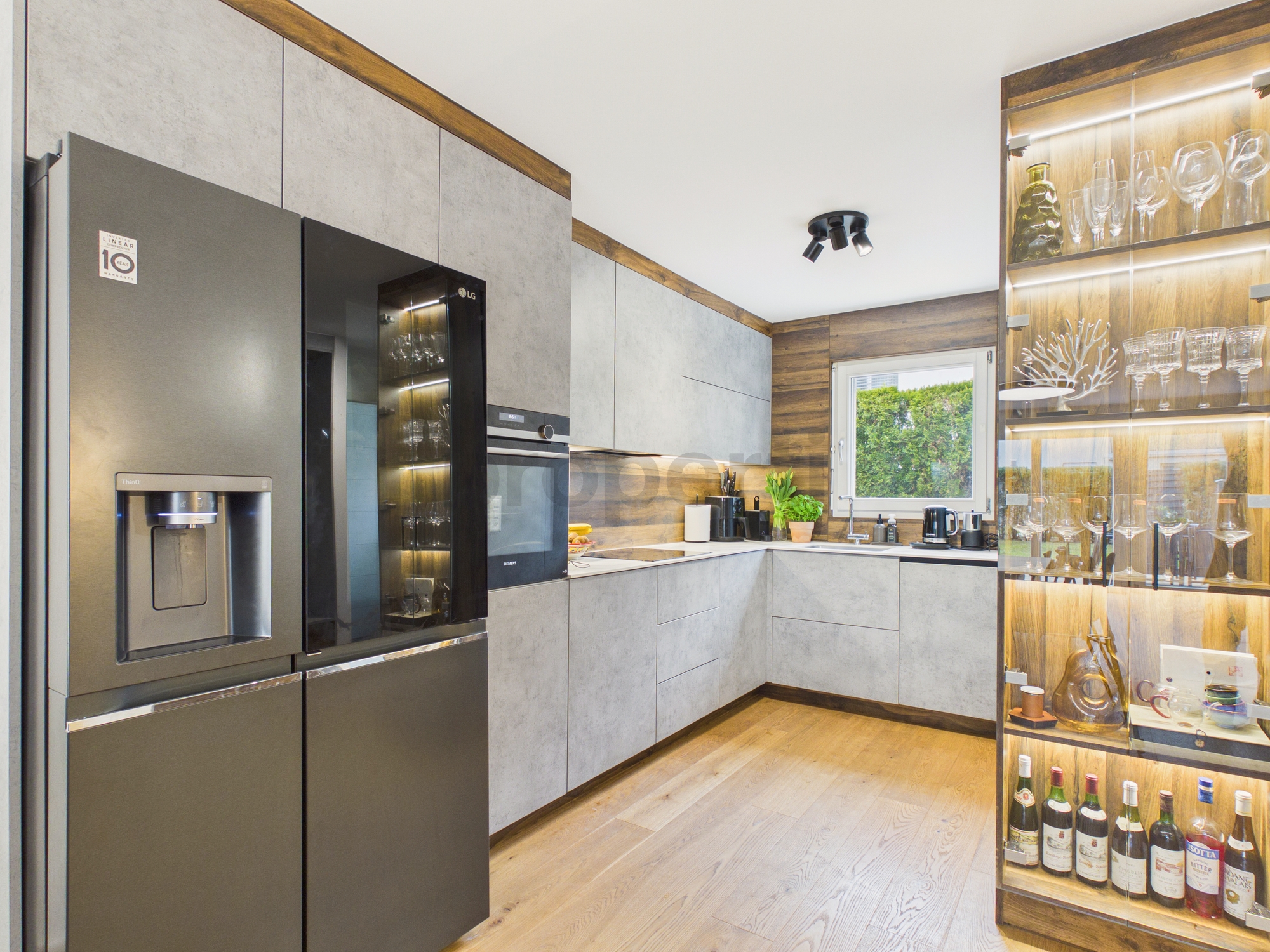 Moderne Küche mit integrierten Geräten und Glasvitrine