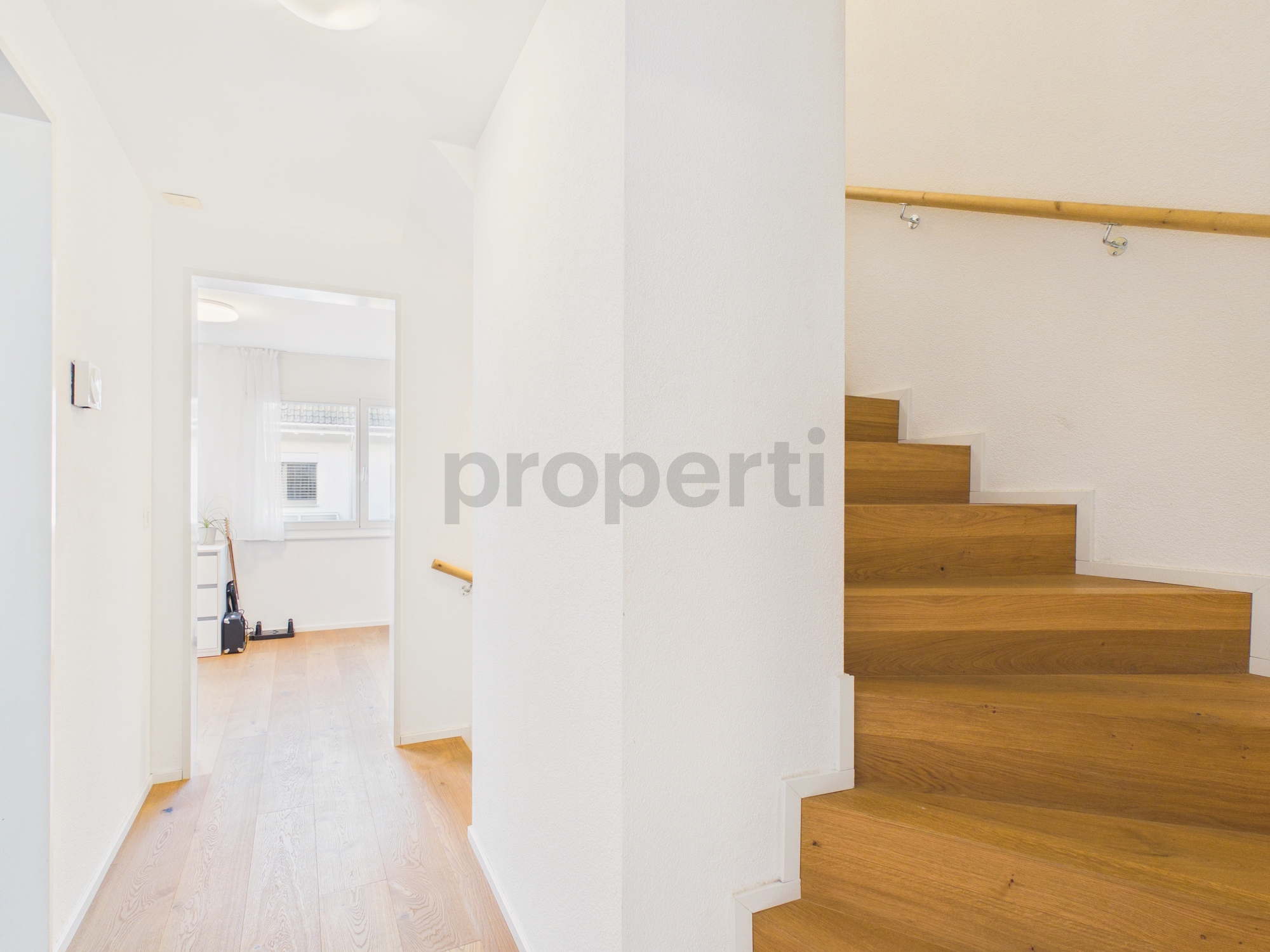 Heller Treppenflur mit Holztreppe
