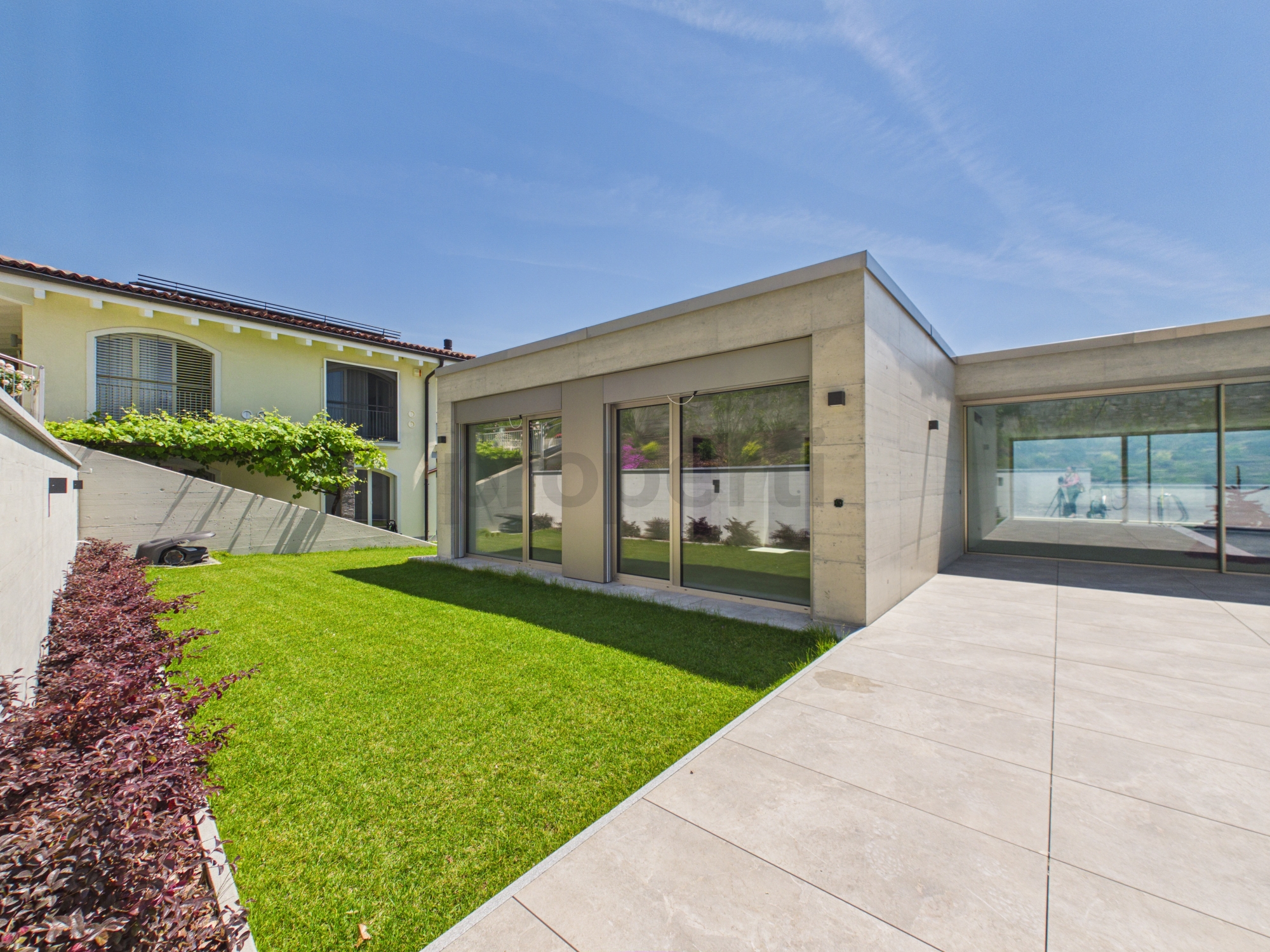 Moderner Innenhof mit Garten und großflächigen Glasfronten
