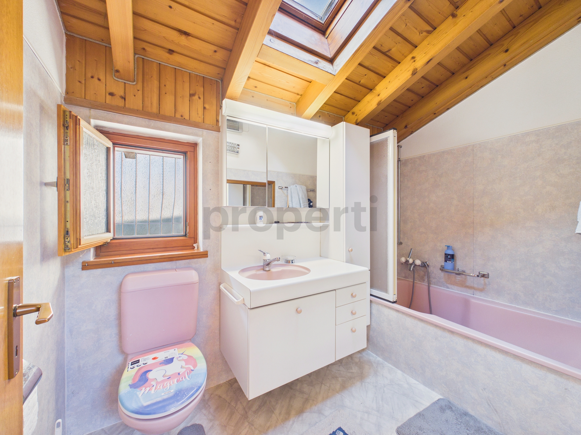 Badezimmer mit Holzdecke und rosa Akzenten