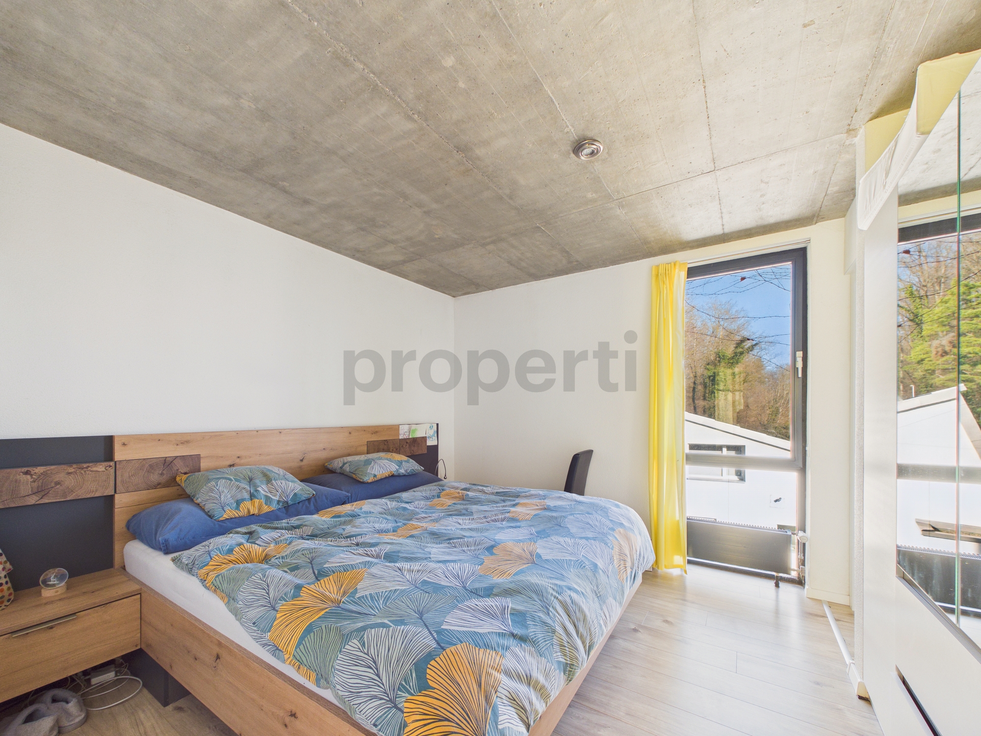 Modernes Schlafzimmer mit Betondecke und Tageslicht