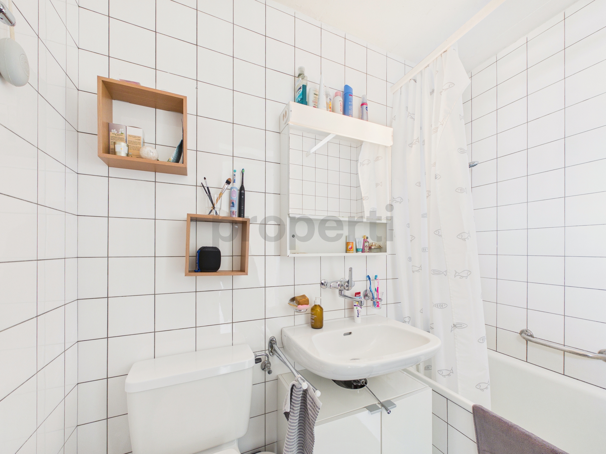 Kleines weiß gefliestes Badezimmer