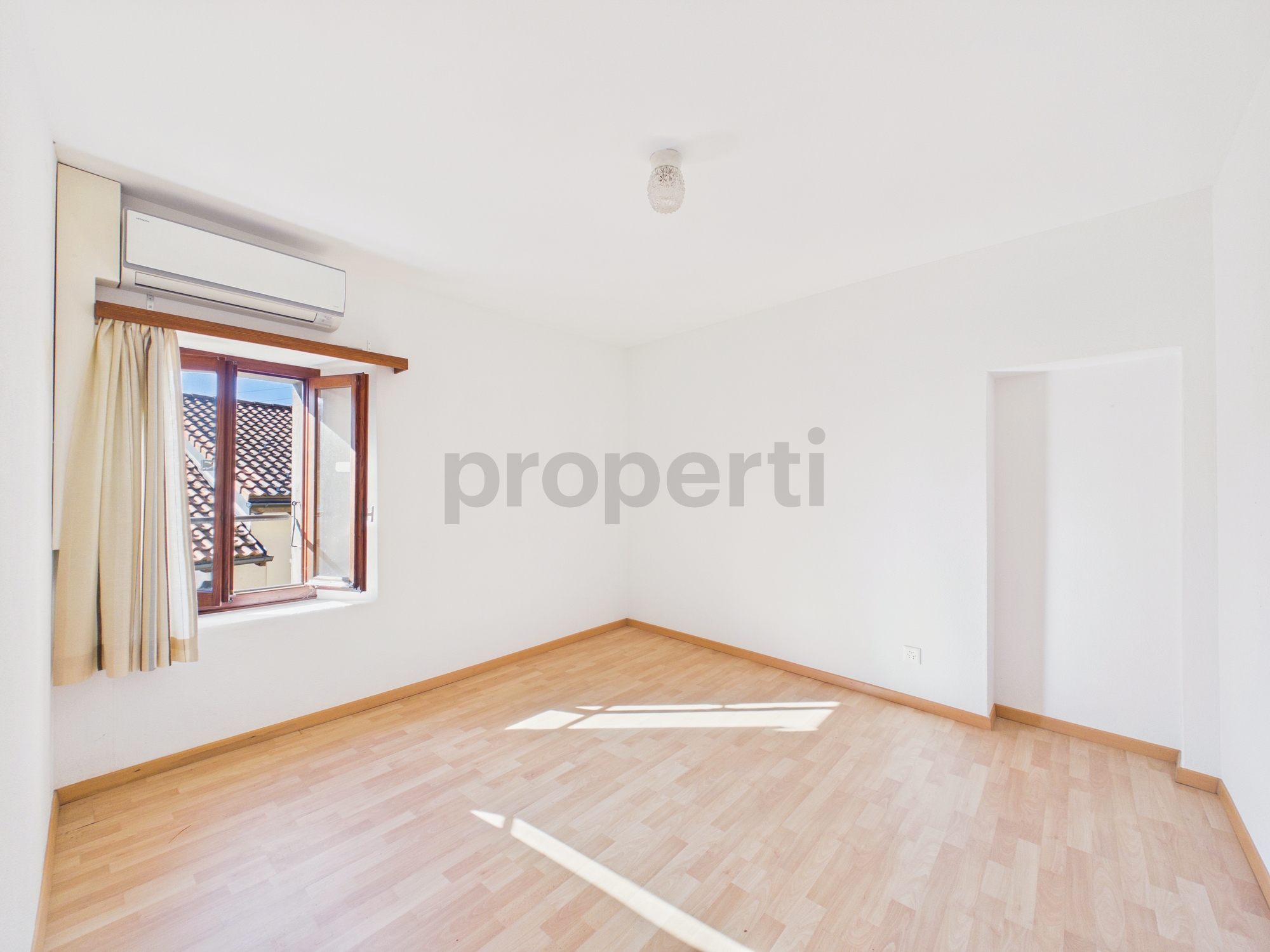 Helles, leeres Zimmer mit Fenster und Klimagerät