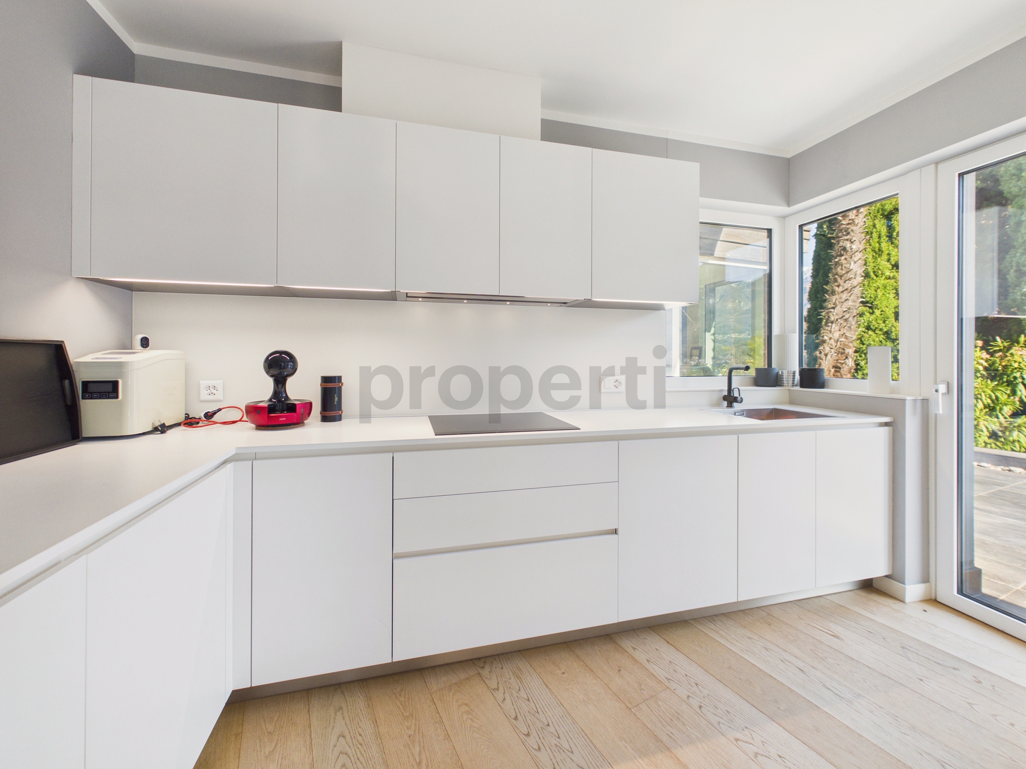 Moderne weiße Küche mit großer Fensterfront